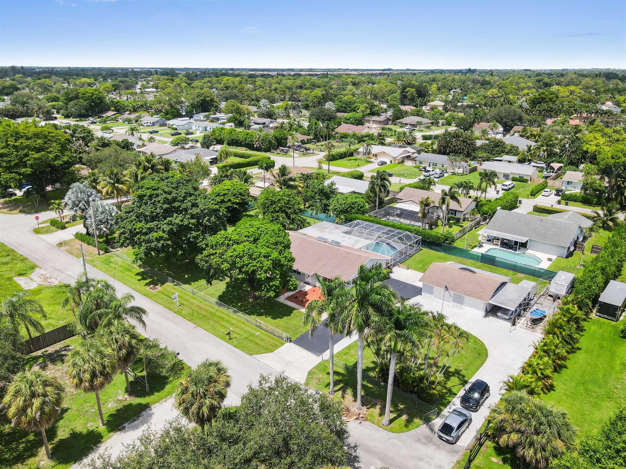 Located in the desirable community of Palm Beach Farms, this spacious pool home sits on over 1/2 acre with no HOA. The 1-story residence offers 2,534 sq ft of living space, plus a 721 sq ft detached 2-car garage, carport, and a circular driveway. Bring your boats, RV's etc! Accordion shutters are installed on all windows for added protection.The home features 4 bedrooms, 4 full bathrooms, and a large den that can serve as a 5th bedroom. The layout includes 2 en-suites, a Jack and Jill bathroom for 2 bedrooms, and a cabana bath with access to the 4th bedroom featuring his and her closets.