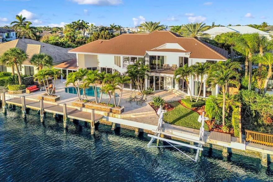 Direct Intracoastal home boasting 100 feet of waterfontage on Jasmine Dr cul-de-sac in Tropic Isle, Delray Beach. Upon entering the residence, the 20+ foot floor-to-ceiling windows showcase the picturesque water views. The home offers ground floor primary suite plus office with built-in murphy bed and cabinets; and two guest bedroom quarters upstairs each with balcony access. Enjoy outdoor living and fun with expansive terrace for dining and lounging amidst Waterway views; pool; built-in grill; custom landscape lighting; dock; and nearby inlet access to the ocean. There is ample parking with a circular driveway and three-car garage with upgraded flooring and built-in cabinetry. Designed for entertaining, this property represents a rare opportunity to own a direct Intracoastal property