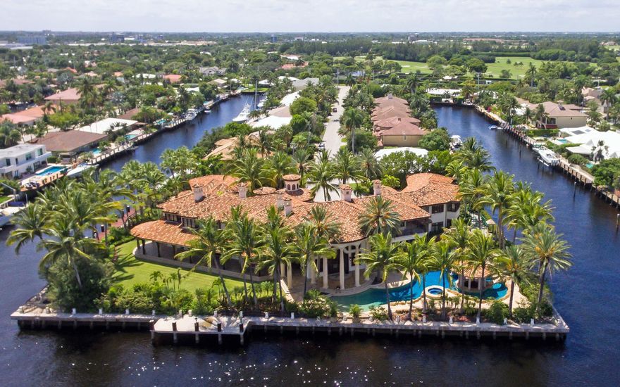 Rarely does a trophy estate such as this come to market. Built in 2004, by expert craftsman, this nearly 24,000 square foot, 7 bedroom, 10 full and 6 half bath home encompasses one acre with 665' of waterfront on 3 sides. There's a resort size 102' pool complete with a swim up grilling station, rock waterfall, waterside, grotto and large sun shelf. Large boats can be accommodated without jeopardizing any of the Intracoastal views. Enter into the 2-story foyer with grand double staircase. To the left you will see the elevator, formal living and dining rooms and his office, all having a working fireplace in each room. To the right, you enter into the 2-story Lodge-style gathering room with huge fireplace & built-in fish tank, wet bar and floor-to-ceiling windows offering breathtaking views.