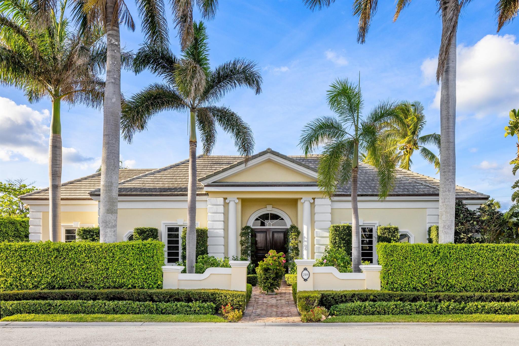 This one-story North End Palm Beach home features five bedrooms, a chef's kitchen, formal dining room, and elegant living areas with high ceilings and hardwood floors throughout. The primary wing includes a spacious luxury bathroom, walk-in closets, and an office/bedroom with its own ensuite bathroom. The family and living rooms and kitchen overlook the lush backyard and pool. A cabana/bedroom with an ensuite bath is located next to the pool behind the 2-car garage, providing privacy for guests to enjoy the backyard in peace.