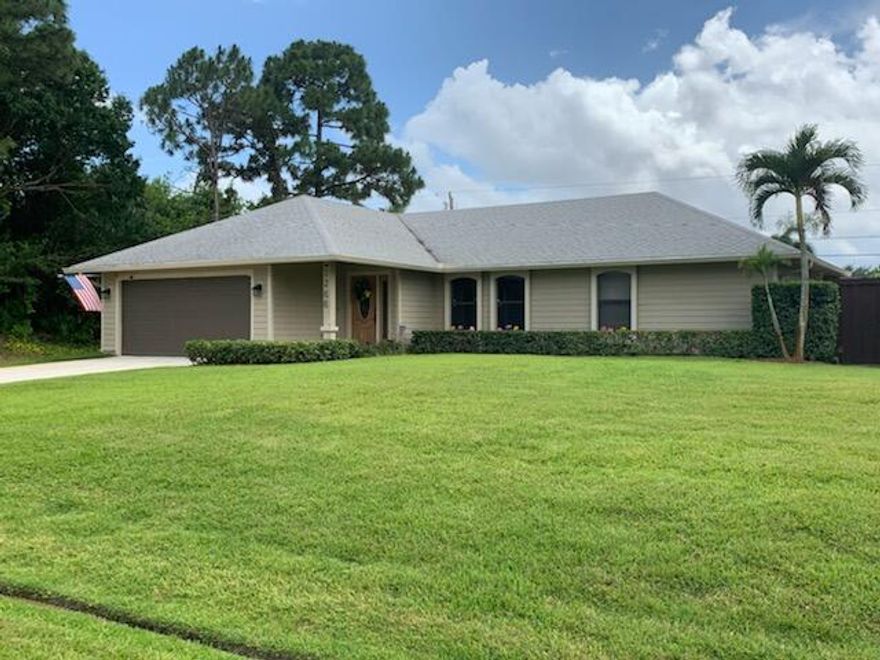 WOW! Fabulous property for entertaining! This 3 bedroom, 2 bath, 2 car garage home offers ceramic tile throughout; 42'' Oak kitchen cabinets and granite countertops; newer fridge; 2013 A/C;  a 2004 Architectural 40 year roof; and, an outdoor shower.  The property is located on a double lot and features complete outdoor bar with water and electric; 12x12 Hot Tub; 20x25 composite wood deck; large screened patio; completely fenced; 20x20 RV  shelter with 30 AMP service and water; 12x16 shed; and a full sprinkler system on well.  Live in your own paradise but only minutes to I-95,  the Tradition shops, restaurants, grocery store, and Walmart and Sams Club.