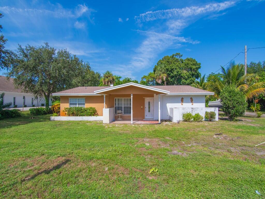 This property offers so much potential and just minutes to local beaches! Sale includes .24 vacant lot behind home included in the sale sits on .47 acres total. Inside is spacious 3 bed 3 full bath, Laminate/tile floors spacious bedroom with option to include a 4th bedroom to the 26x11 closed Florida room equipped with its own closet and windows. Formal everything with dining, living room and a large kitchen with exten bar. Lots of space surrounding this home with 1,976 sqft and an extended road on the side next to a large 2 car garage delivering options to park your toys.