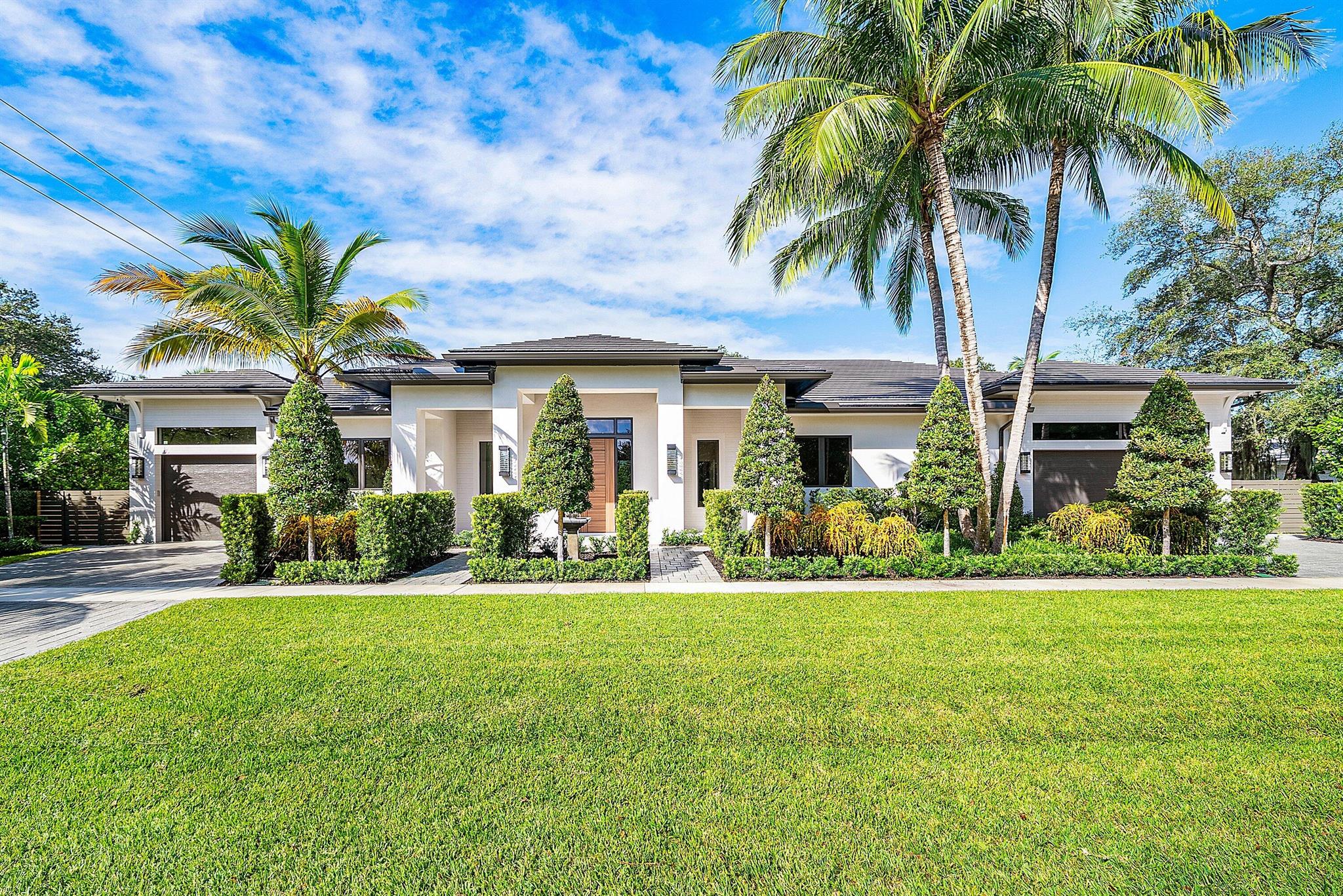 Introducing a Masterfully Crafted Estate That Defines Contemporary Elegance. Perfectly positioned in East Boca Raton's coveted Palm Beach Farms, this stunning one story residence blends architectural sophistication with effortless livability. Expansive, light-filled living spaces flow seamlessly to the outdoors, creating a natural setting for both grand entertaining and intimate gatherings. The great room features a soaring 14-foot ceiling, dramatic Dimplex fireplace, custom wine display, and bar setting the tone for refined yet inviting living. The chef's kitchen showcases top-of-the-line appliances, a generous walk-in pantry, and exquisite craftsmanship that continues throughout the residence.