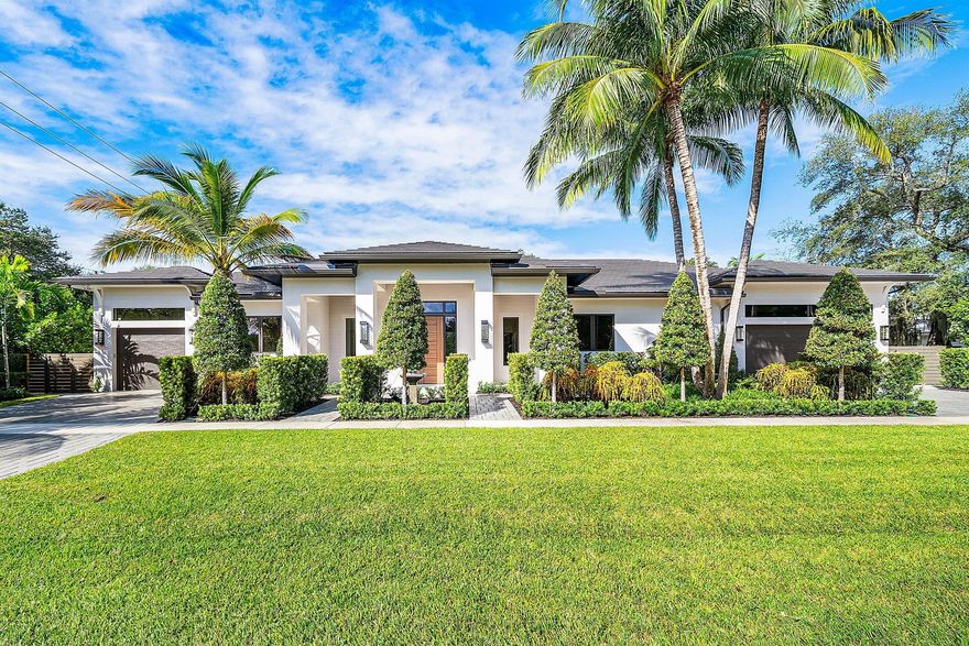 Introducing a Masterfully Crafted Estate That Defines Contemporary Elegance. Perfectly positioned in East Boca Raton's coveted Palm Beach Farms, this stunning one story residence blends architectural sophistication with effortless livability. Expansive, light-filled living spaces flow seamlessly to the outdoors, creating a natural setting for both grand entertaining and intimate gatherings. The great room features a soaring 14-foot ceiling, dramatic Dimplex fireplace, custom wine display, and bar setting the tone for refined yet inviting living. The chef's kitchen showcases top-of-the-line appliances, a generous walk-in pantry, and exquisite craftsmanship that continues throughout the residence.