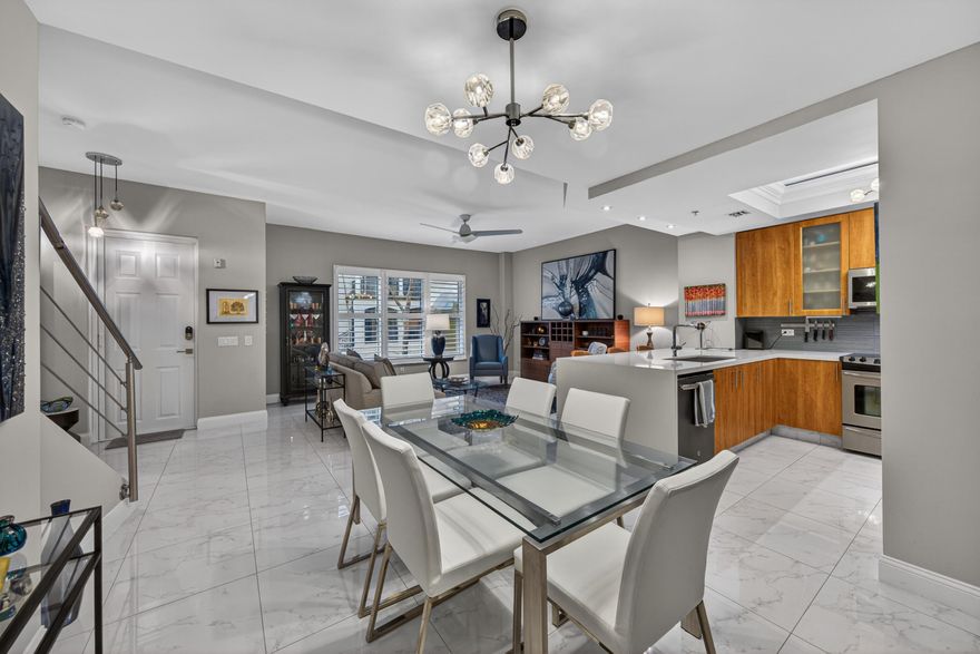 Beautifully appointed 2-bedroom plus den and boutique office, 2.5-bath townhome in gated Wilton Station, ideally set along the Main Promenade in desirable Village Lane. This two-story residence showcases elegant porcelain tile throughout, striking glass and cable railings, and a designer kitchen with quartz countertops, waterfall edge, and stainless steel appliances. Plantation shutters, custom closets, and two tastefully remodeled baths enhance the home's refined feel. The sunlit second bedroom features dual French doors, with private balconies off both bedrooms. Complete with retractable screens, underground parking, and storage. Enjoy resort-style amenities including pool, clubhouse, fitness center, and more—all just moments from beaches, dining, and vibrant Wilton Manors nightlife.