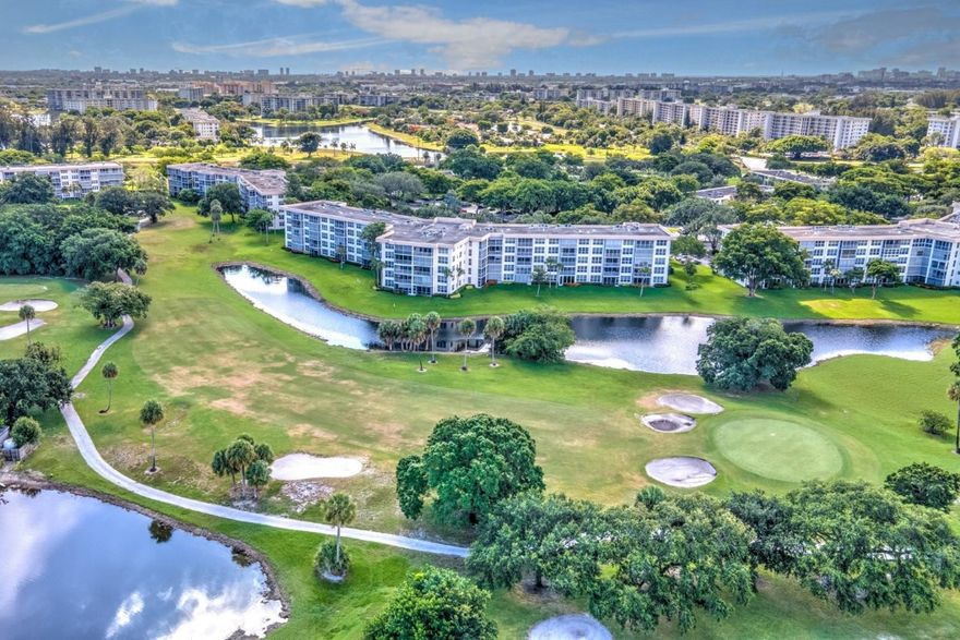 *Palm Aire* CORNER 2nd floor 3/2 with expansive view of the lagoon & golf course that's priced to sell! As you enter the apartment you see the beautiful views through the IMPACT windows.  Ceiling fans in bedrooms and screened balcony.  White kitchen appliances and full-size stackable washer & dryer.  Furniture is 2 years old. Unit owned by two families over the years, is well maintained, and only used as a vacation home. Association fee includes 1 assigned parking spot & storage unit, water, cable, Internet, trash, & sewer. Amenities include pool, clubhouse, pickleball, tennis, playground, basketball court, and jogging path.  Community pools with grills directly across from building.  Building lobby renovated 2020 w/ new impact doors, building roof 2017, and 40-year certification passed.