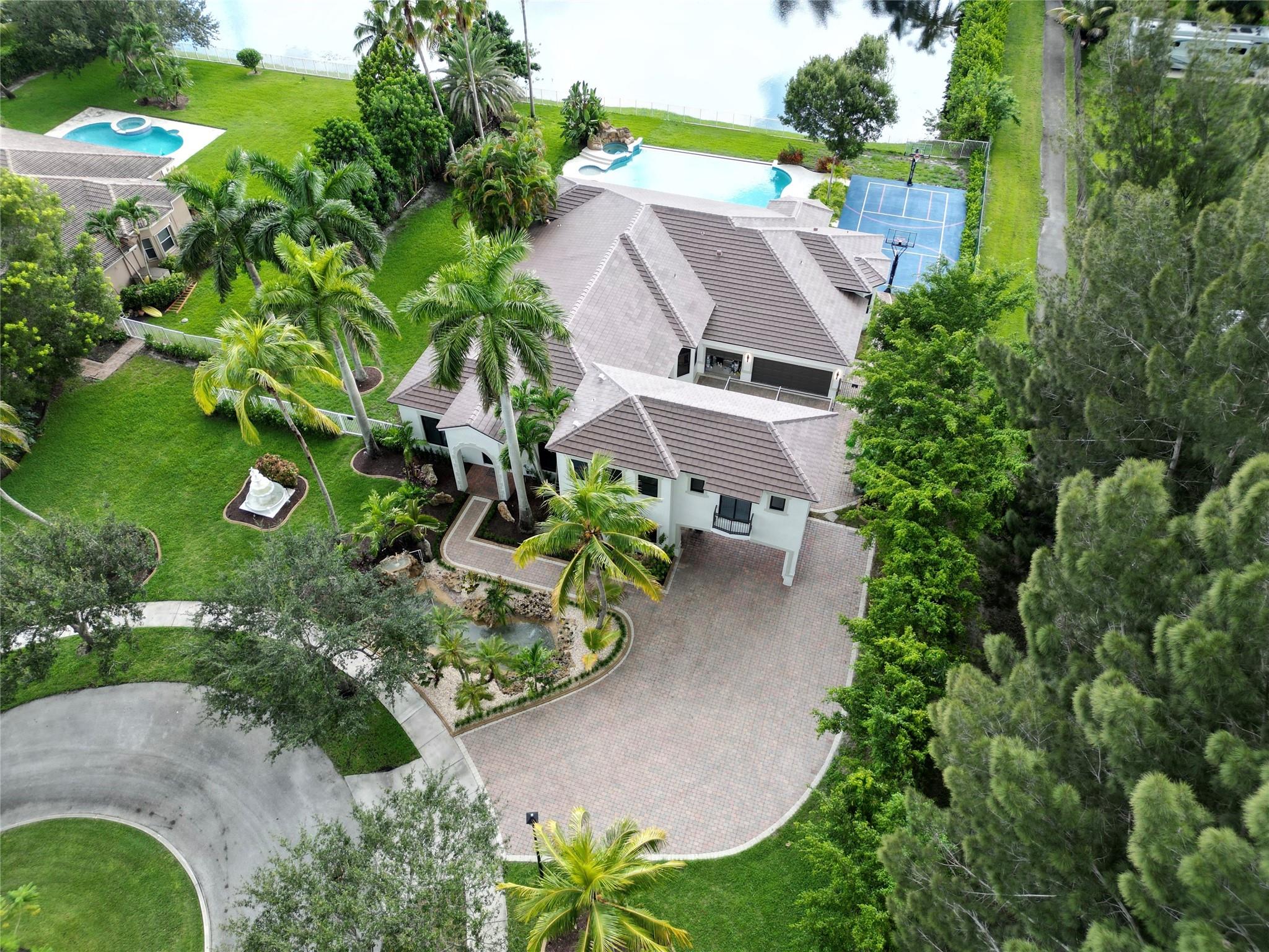 Where modern upgrades meet timeless luxury. Located within the exclusive gated community of Saddlebrook, this 6BR/5BA Davie estate brings you resort-style living. A brand-new 2025 roof (transferable warranty), new impact windows and doors, and new high end upgrades/finishes throughout. Inside, enjoy a chef’s kitchen with custom cabinetry boasting Wolf & Thermador appliances, an executive office, and a theater/extra room. The upstairs loft with private suite adds flexibility. Outside, relax by a 50+ ft pool with spa & kiddie pool, play on your own private pickleball and basketball court, or unwind on the tranquil 25ft long koi pond. Set on nearly an acre with parking for 12+ cars, this is where elegance meets everyday comfort and fun.