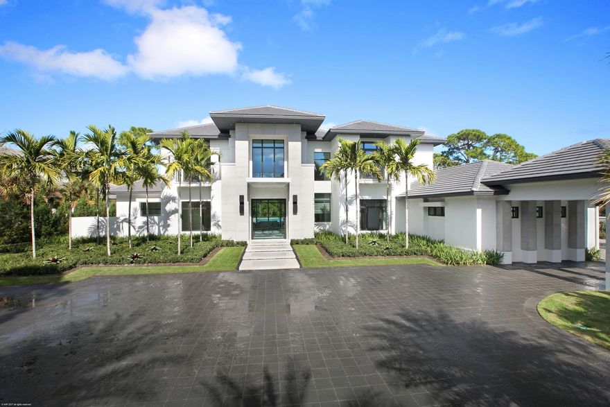 Located in the exclusive Bears Club Community of Jupiter, just steps away from the famed Jack Nicklaus Golf Course, this luxurious contemporary home by Marc Julien Homes is nothing short of exquisite. This five bedroom, six-and-two-half bath estate has it all, and then some. Boasting nearly 9,000 square feet, and featuring a 10' x 8' automated glass front door, expansive open floor plan incorporating both indoor and outdoor living areas, double height ceilings, marble and hand-scraped hardwood flooring, formal dining room, and a 75' pool with infinity edge spa. The quintessential Poggenpohl gourmet kitchen opens to the spacious family room and is complete with a 200-year-old Nicaraguan Walnut bar with seating for five, a complete Wolf appliance package, breakfast nook, and ultra-contemporary stainless steel backsplash. Pocket sliders in the family room and clubroom open to the spacious covered loggia that features automated bug-screens, two fireplaces and a summer kitchen providing the perfect setting for entertainment and relaxation. The first-floor master wing is complete with stunning his-and-her custom bathrooms and closets, and an expansive seating area with sliders that open directly to your private patio overlooking the lush backyard. Moving up the floating walnut staircase to the second floor you will find the lounge complete with unprecedented golf course views, balcony, built in desk and a subzero under cabinet refrigerator. Finishing off the second floor are three additional bedrooms all with designer en suite bathrooms. Additional features include a generous guest house with one bedroom and full bath; an entire home automation system that controls audio, video and lighting; three gas fireplaces; expansive yard; first and second floor laundry rooms; wood and marble flooring; designer finishes and custom ceilings throughout; impact doors and windows; large four car garage and much more. The entire home was created to have an open, sophisticated, and luxurious style while incorporating the beauty of the property.