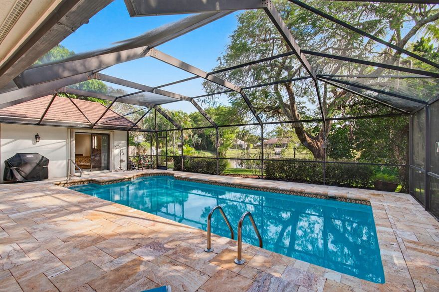 Hidden behind lush, mature landscaping and offering complete privacy, this LAKEFRONT Greenview Shores home delivers a rare sense of tranquility in Wellington-NO HOA and a dedicated area for your BOAT or RV. The four-bedroom residence features a large, screened pool with marble decking, a private dock accented by a magnificent Royal Poinciana, expansive green space, and a large, covered patio with accordion shutters that allow the space to be easily enclosed-ideal for effortless furniture storage while traveling. As you enter through the impact-rated double fiberglass doors with elegant decorative glass, you are welcomed into a bright and flexible living and dining area. The current layout features a spacious dining room with the ability to expand, while the living room captures beautiful views of the lush backyard and lake beyond.

When this quality Ruttenberg home was thoughtfully renovated years ago, quality finishes were selected throughout-choices that have stood the test of time. The kitchen offers abundant maple cabinetry, glass cabinets, Corian countertops, pull-outs, a Lazy Susan, under-cabinet lighting, and stainless-steel appliances including a slide-in range, French-door refrigerator, and wine refrigerator. Numerous sliders throughout the home create a seamless connection to the outdoor living areas and highlight the tranquil lakefront setting.

The primary suite features sliders opening directly to the covered patio-an ideal spot to enjoy morning coffee overlooking the water. Two closets and a spacious primary bath complete the suite, featuring an upgraded shower, enhanced tilework, a seamless glass enclosure, and generous cabinetry and counter space that continues the cohesive maple cabinetry found throughout the home.

Adjacent to the guest bedroom wing, a large family room offers a welcoming gathering space with a wood-burning fireplace, vaulted ceilings accented by transom windows, and an inviting atmosphere for everyday living or entertaining. The guest bedrooms are in their own separate wing, allowing for excellent privacy, and can be closed off with pocket doors-ideal for guests or multi-generational living.

Two of the guest bedrooms enjoy views of the lake or pool. The guest bath also serves as a cabana bath and features upgraded tile and listello detailing. The laundry room is equipped with cabinetry, a sink, and a built-in pull-down ironing board.

The oversized garage includes built-in cabinetry and shelving, along with a convenient side service door. Additional features include solid wood interior doors, three hurricane-rated skylights that bring in abundant natural light, mature mango tree, star fruit tree, banana trees, accordion shutters, front screened-in porch, an RV plug on the side of the home, pump to the lake for sprinkler, and two outdoor storage sheds.

Ideally located in the heart of Wellington, this home is close to world-class equestrian venues, hospitals, shopping, dining, A-rated schools, and is just a short golf cart ride to everyday conveniences.
This impeccably maintained residence reflects true pride of ownership and offers a rare combination of privacy, flexibility, and location. Opportunities like this in Greenview Shores are seldom available.