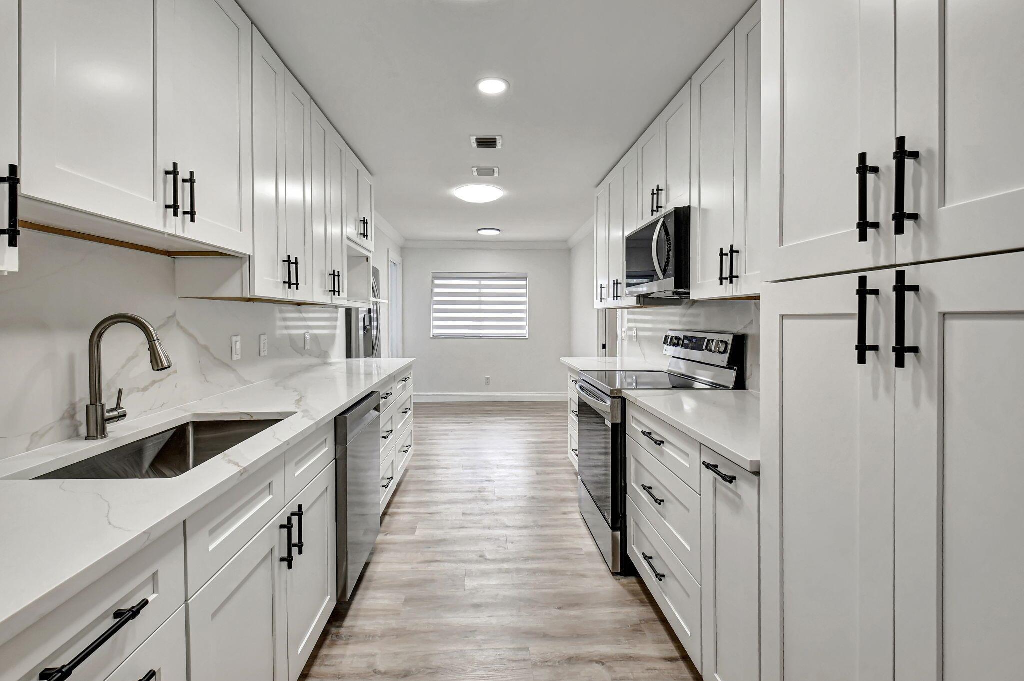 Tastefully remodeled 3BR/2.5BA villa in The Fountains of Palm Beach, Versailles Court section. Bright, spacious layout with vaulted ceilings, skylights, and modern finishes. Updated kitchen with white wood cabinets, quartz counters, and new stainless steel appliances. Primary bath features freestanding tub filler and frameless glass shower. Laminate flooring throughout. Backyard overlooks golf course. Community offers 3 pools. All ages welcome. Move-in requires first month, last month, and security deposit. Easy to show--schedule via ShowingTime.