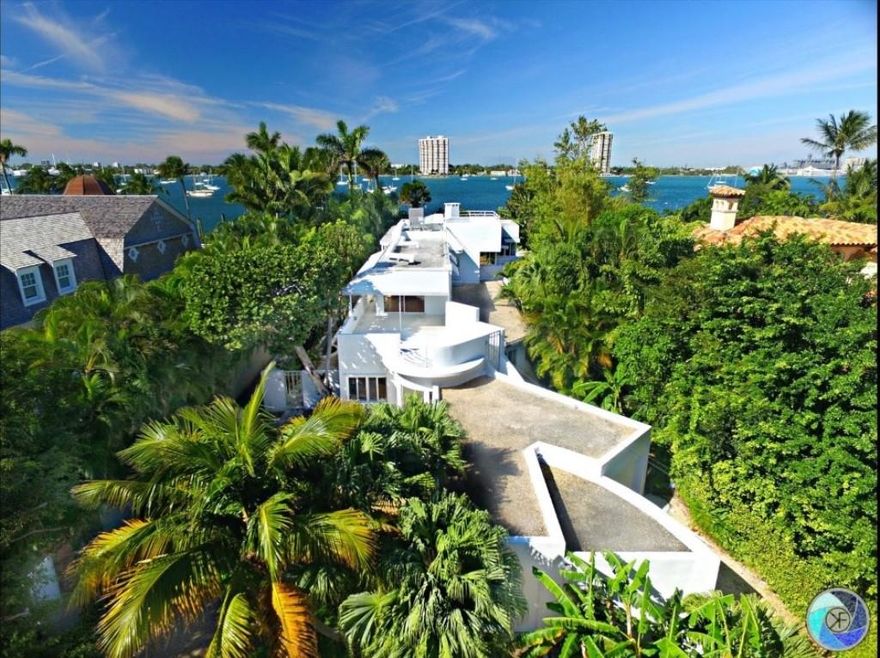1221 North Lake Way was built in 1940 and designed by Belford Shoumate who was the most popular architect of Modernism on the island of Palm Beach. Designed as a 6,000 SF 'Nautical Mansion' the 'Fore and Aft House' was featured in the 1939 World's Fair as one of the Houses of Tomorrow.  That fair had a lasting influence on American Architecture.Following Art Deco, the International Style of Architecture grew out of a fascination with industrial design and speed, particularly, automobiles, trains, boats and planes.  The southern elevation of the 1221 has concrete porthole columns that repeat along the windowed curtain wall and the upper decks feature steamship railings. The extreme right of the house (eastern elevation) has a 2-car Y shaped garage with 2 exits.