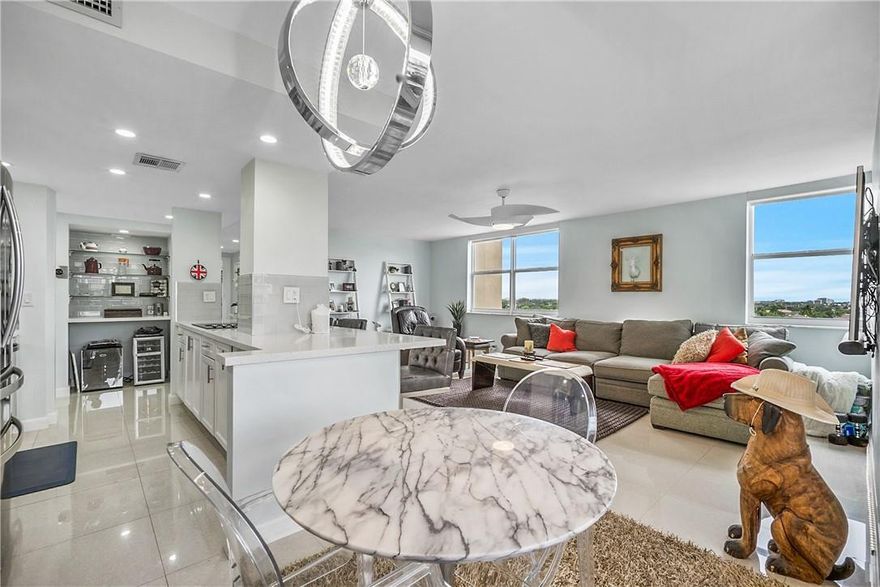 This immaculate, well appointed corner unit overlooks the intracoastal with sweeping views of the cityscape and the ocean beyond. Savor the sea breezes and watch boats passing by from the balcony. Featuring impact windows full of natural light, quartz counters, stainless appliances and porcelain tile throughout. Impressive master suite with a ridiculous amount of room for the wardrobe. Within walking distance of many fine restaurants on both sides of the water, pharmacy, shops and a 15 minute stroll to the beach or to the Coral Ridge Country Club. This was completely renovated in 2016. Covered garage parking space #72, heated pool and dock space available (35 ft maximum).$590 total monthly HOA ($56 goes to a reserve that includes cable and internet). Turn key, some furniture negotiable.
