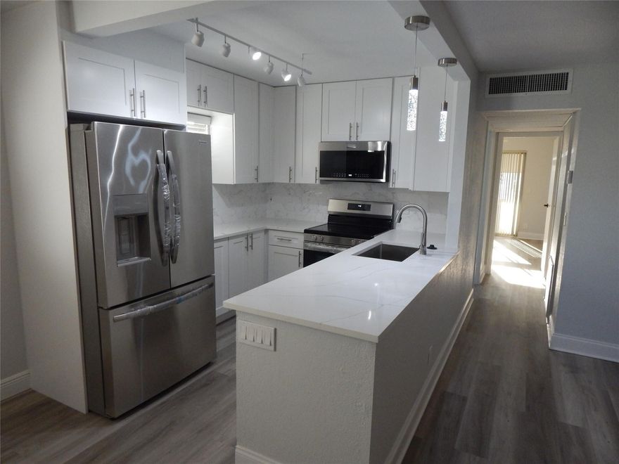 RENOVATED UNIT and MOTIVATED SELLER. New luxurious Kitchen and bathrooms in an affordable condo. Calacata Quartz on kitchen top and bathrooms vanity tops. New quality appliances. Touchless faucet on kitchen. All new cabinets, mirror, lights, toilets on bathrooms. Calacata porcelain tiles on both baths.  Freshly painted.  New impact front door.  Newer Air conditioning, 2022. It's a must see it unit before you buy anything. This first-floor unit has a parking spot direct on to the back patio door, making easy to bring your groceries.
