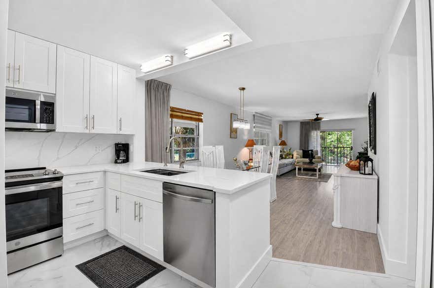 Welcome to effortless luxury living in the heart of Delray Beach. This fully furnished, designer-updated residence offers the perfect blend of style, comfort, and convenience in a private corner end-unit setting with tranquil preserve views. Tucked away at the back of the community, this beautifully remodeled condo delivers an elevated lifestyle just minutes from Downtown Delray, pristine beaches, shopping, dining, and major highways.  Inside, the home showcases rich wood flooring, luxury cabinetry, stainless steel appliances, and beautifully renovated bathrooms with timeless finishes throughout. The thoughtfully designed layout is filled with natural light and opens to a screened-in private balcony overlooking lush greenery—creating the perfect space to relax and unwind.  The spacious  kitchen flows seamlessly into the living and dining areas, while the in-unit washer and dryer provide everyday convenience. Offered fully furnished, this move-in ready residence is ideal for seasonal or annual living.  Residents enjoy resort-style amenities including a community pool, fitness center, tennis courts, and pickleball courts. A covered designated carport parking space is located directly in front of the unit, with abundant guest parking nearby for added convenience.  Experience low-maintenance luxury living in one of Delray Beach's most desirable locations.