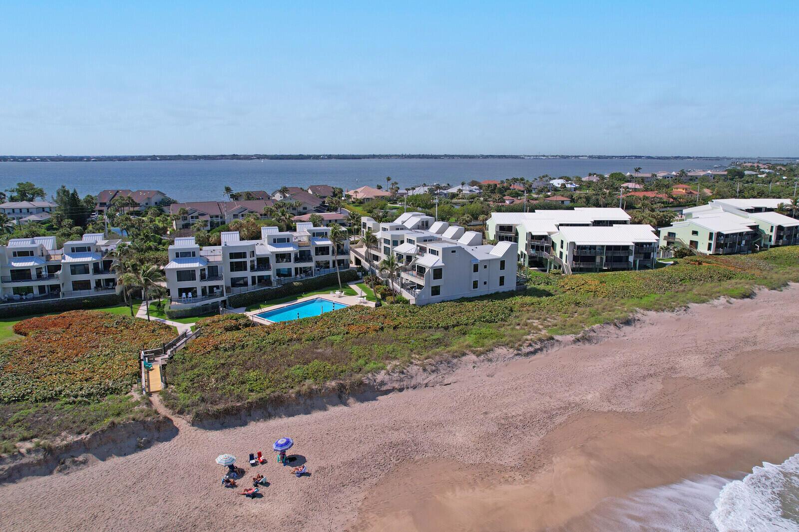 Wake up to breathtaking sunrises over the ocean and wind down with stunning sunsets over the river-all from your private expansive rooftop deck, featuring new composite decking. The beautiful 2 story, beachfront condo offers a large main bedroom, guest room, and bonus loft with 1/2 bath. Step inside to find an elegantly remodeled kitchen with new Kitchen-aid stainless steel appliances, induction stovetop, high end cabinetry, eat-in nook, & counter with seating. The open concept living area boasts new LVP flooring, while the hallways and bathrooms showcase timeless travertine. Custom closets throughout with plenty of storage. Maritimes community offers private beach access, 2 heated pools, pickleball/ tennis court, beach on river side to launch kayaks and paddle boards, beach chair storage