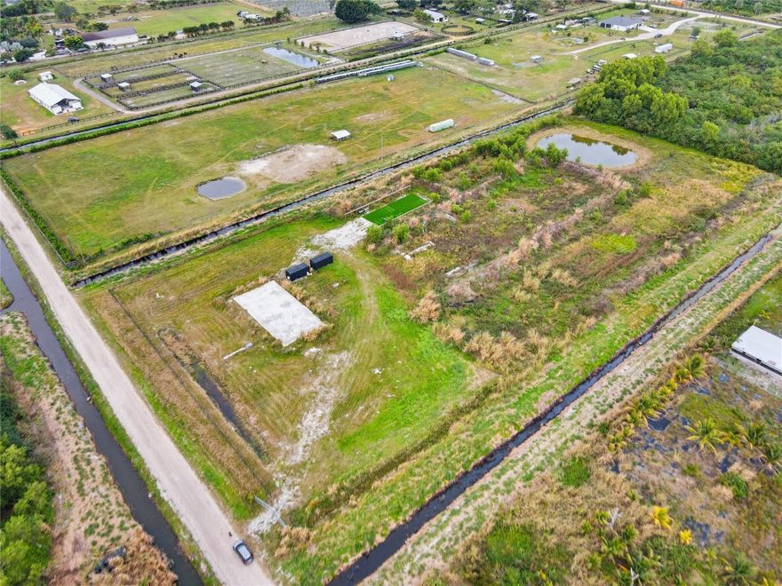 BUILD-READY**6.35 acre parcel in Loxahatchee with extensive improvements already in place. Property features fully fenced and cleared acreage, a 100x100' concrete slab, well and septic installed, plus berm and drainage enhancements, Extensive site preparation completed to enhance elevation and usability, creating high-and-dry usable home site. Ideal for residential, agricultural, equestrian, or estate use. Major site improvements already completed, reducing build time and upfront cost for the next owner. Convenient access to major roadways and local services while maintaining privacy and open space. A rare opportunity to acquire improved acreage in the desirable and growing area Santa Rosa Groves. NO HOA!!  Well suited for a variety of residential, agricultural, and investment uses.
