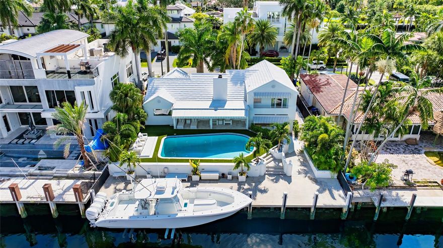 The Hamptons meets Fort Lauderdale on the prestigious South Las Olas Isles in this Reimagined Chic Coastal deepwater estate sited on 75+/-ft of waterfrontage with 25,000+/-lb lift on a concrete dock, 4 off the point & overlooking all new waterfront estates. Stately Royal Palms greet guests to the steel-case double entry doors & Great Room oasis of bleached wood floors, dreamy white walls, skylit vaulted ceilings & cozy fireplace. Primary suite w/dual wardrobes, spa bath w/dble vanity, free-standing tub, & sep shower. Sleek Gourmet kitchen w/ S/S appliances opens to the Family Rm & Dining Rm. The 2nd level floor boasts 2 bedrooms. Resort-like pool patio w/ Lg lanai. Other amenities: Designer furnished, impact windows &doors & 2 bay tiled garage. Minutes to Las Olas Village & famed Beaches.