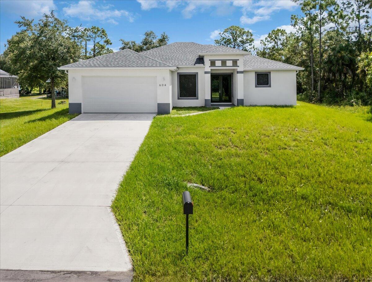 Welcome dream home in Lehigh Acres! This stunning new construction single-family home has 3 bedrooms, 2.5 bathrooms, den and a 2-car garage. The kitchen features quartz counters, stainless steel appliances, large island and a pantry. The vinyl wood flooring throughout the home is stylish but and easy to clean. With impact windows and doors, you can rest easy knowing your home is protected during storms. The 14 foot vaulted tray ceilings add a touch of elegance to the space. The primary bedroom has his and her walk in closets. The primary en-suite has a private lavatory, walk-in shower and dual vanities. Cleared half-acre lot for outdoor activities. This home comes complete with all fans, modern fixtures and LED lighting. Call today for showing.