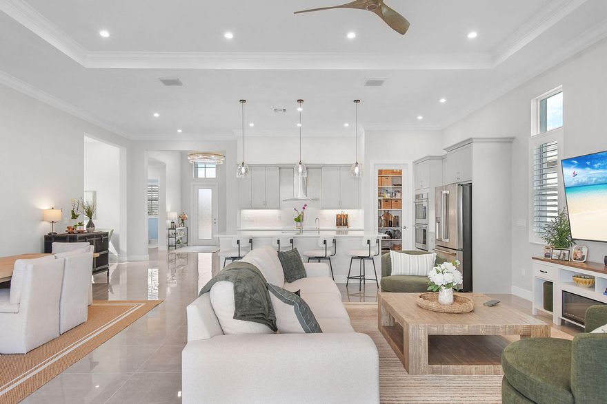 Experience the pinnacle of resort-style living in PGA Village Verano with this highly upgraded 2024 Kolter-built lakefront residence set on a premium wide-water homesite with ideal southern exposure. Designed for the most discerning buyer, this 3-bedroom, 3-bath home with a 3-car garage showcases over $200,000 in builder and post-closing upgrades, offering a move-in-ready luxury lifestyle without the wait to build.

From the moment you enter, the home impresses with 24x24 high-gloss tile flooring throughout, upgraded solid-core interior doors, custom moulding, and a stunning Therma-Tru privacy glass entry. The open-concept design is enhanced by oversized sliding glass doors that seamlessly connect indoor and outdoor living while framing breathtaking long lake views and all-day southern light.
The chef's kitchen was thoughtfully upgraded with GE Café appliances including a 36" induction cooktop, double ovens, chimney hood, and expanded cabinetry, complemented by full-height backsplash, glass pantry door, designer lighting, and extensive storage, ideal for entertaining and everyday luxury. Spa-inspired baths feature floor-to-ceiling tile, frameless showers, upgraded vanities, and extended mirrors, creating a true retreat feel in every space.
Step outside to a dramatically expanded 20x40 screened lanai with pavers overlooking wide water, perfect for sunrise coffee, evening gatherings, and enjoying Florida's indoor-outdoor lifestyle year-round. A premium hot tub, additional exterior lighting, and full-home gutters further enhance comfort and functionality.
Additional highlights include:

Custom closet systems throughout
Plantation shutters in all rooms including garage
Designer lighting and ceiling fans
Whole-home paint upgrades
Reverse osmosis water system
Insulated garage with mini-split A/C
Tesla charger service + additional dedicated electrical upgrades
Added attic flooring and overhead storage
Located in PGA Village Verano, residents enjoy a resort-caliber lifestyle with a spectacular clubhouse campus, fitness center, indoor and outdoor pools, tennis, pickleball, social clubs, dining (PGA Village), and year-round activities, all within a gated, beautifully maintained community.
This is a rare opportunity to own a nearly new, extensively upgraded waterfront home on one of Verano's most desirable lots, where luxury, lifestyle, and location come together seamlessly.