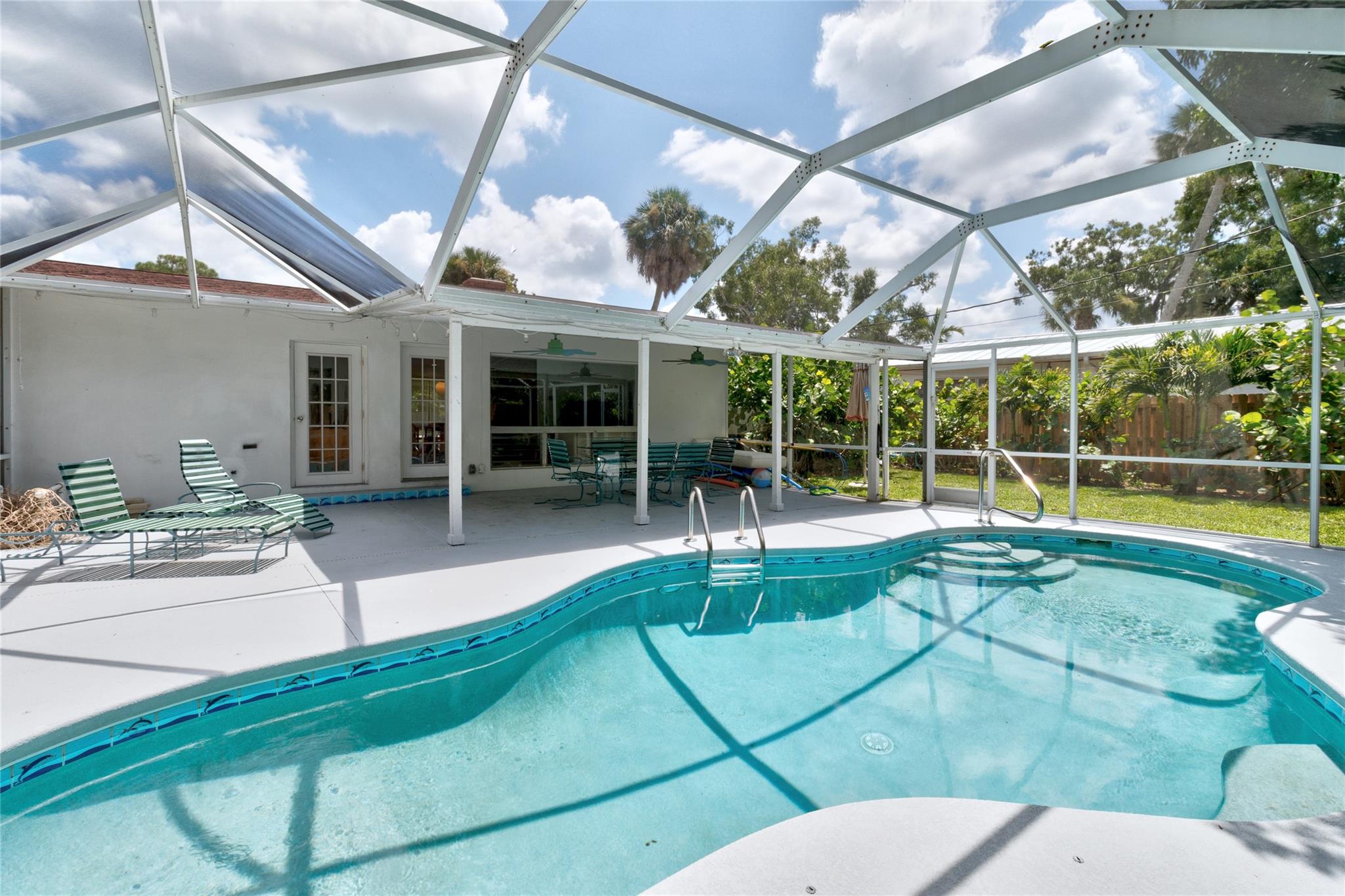 Beautifully updated furnished CBS POOL home on quiet street with neighborhood park and less than 4 miles to the BEACH. 2020 Roof /2021 AC, Fantastic kitchen with loads of storage, SS 2022 appliances + breakfast nook. Living room is light & bright with fireplace, dining space and a wall of windows. Dreamy vintage bathrooms, with updated plumbing (2025). Second bedroom is oversized + has room for a ensuite office with pool views, LARGE screened in patio 30x33, with ample covered space for eating outside and plenty of decking to provide you with areas to sun!! ALSO has a FULLY FENCED backyard