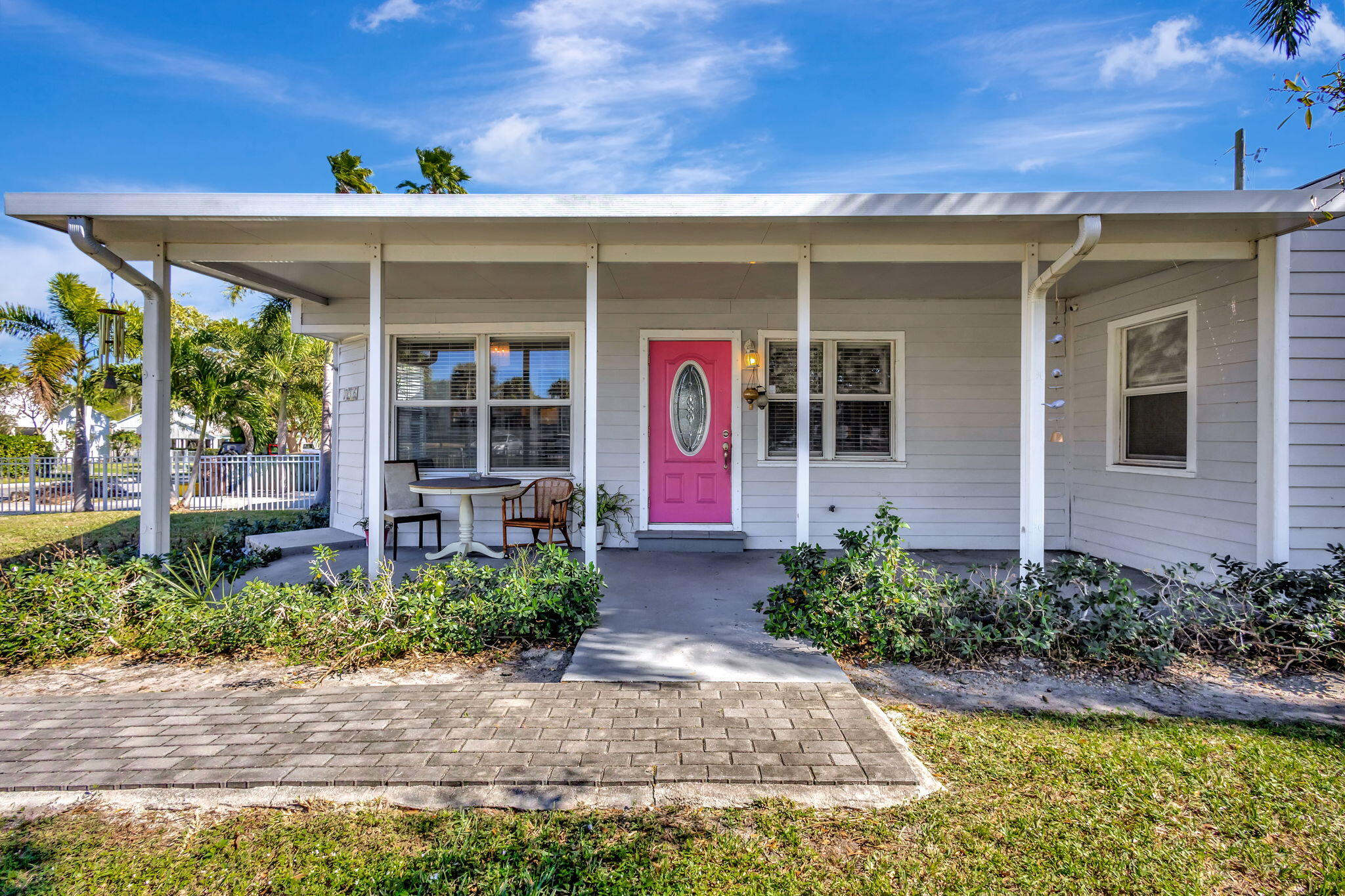 A welcoming covered porch sets the tone for this charming four-bedroom, two-bath home just 5 miles from the beach. Inside, natural light fills the bright and airy layout, highlighted by crown molding, wood floors and a kitchen with crisp white cabinetry, french doors, and a buffet pass-through. Central A/C keeps the home comfortable throughout, with a window unit in the primary bedroom for separate cooling. The fenced yard offers plenty of space for pets or gardening, while shared laundry access adds everyday convenience.This home offers both convenience and charm--all while being minutes from the shops, dining, and vibrant energy of downtown West Palm Beach. Whether you're seeking a serene retreat or a well-located spot close to it all, this is the perfect place to call home.