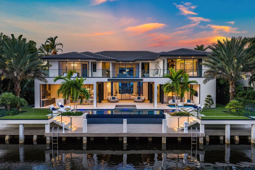 A striking new waterfront estate by Albanese & Sons, architecture by BE Design, and interiors by Zelman Designs, debuts in Royal Palm Yacht & Country Club. This ultra-luxury residence spans just over 9,000 sq ft of refined interiors with 100 feet on the Royal Palm Waterway and captivating Capone Island nature preserve views. Thoughtfully designed for effortless living and grand entertaining, it features a club room with bar, glass wine display, wellness suite with sauna and steam shower, and a state-of-the-art Control4 innovative system. Outdoors, a southern-facing infinity pool, spa, and sunken fire pit create a private resort ambiance. Don't miss this extraordinary turnkey masterpiece.