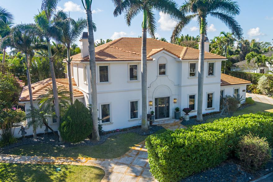 Set on a 16,775 sf, high-elevation lot, this estate showcases timeless architecture & refined detailing, impact glass, whole house generator. Volume ceilings, custom moldings, & abundant light enhance well-scaled interiors. Striking iron entry & wraparound staircase create a grand yet welcoming arrival. Chef's kitchen features gas range, dual refrigerator/freezer. Primary suite offers a private sitting room, terrace, and dual baths, while all guest suites offer equally refined comfort. Executive study with fireplace, wine/beverage features. Oversized garage. Lushly landscaped grounds surround heated pool, summer kitchen, Zen-inspired gazebo spa, & glass solarium fit for a playroom or even a greenhouse. This special residence is ready for you to make your own. Some images digitally refined.