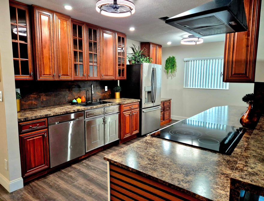 This exquisite home and spacious model with many beautifully upgraded features throughout: Dream Kitchen and appliances, 3 bedrooms and 2 baths with an office nook. It boasts an open and split floor plan, attractive laminate  flooring. New IMPACT Windows , tankless water heater, electric panel. ALL WORK WAS COMPLETED WITH PERMIT! Up to todays code! INSURANCE DISCOUNT! Beautiful designer landscaping. Private backyard really allows you to enjoy South Florida Best Lifestyle. Walking distance to clubhouse and huge parking area. You must see it before it's GONE! Enjoy very  low HOA fees, clubhouse, pool & active community amenities. Prime location close to shopping, dining, beaches & entertainment. Schedule your showing today!