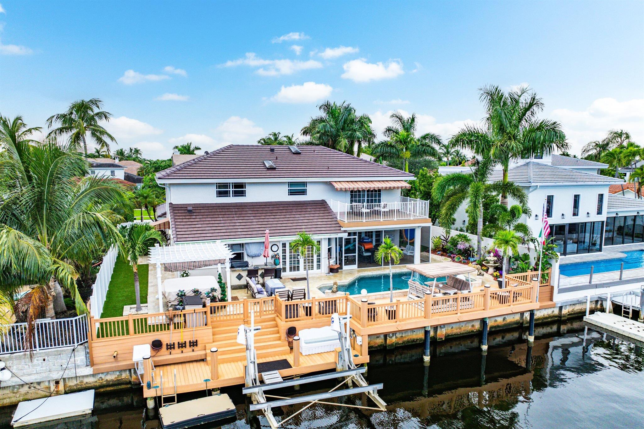 A rare opportunity to own a waterfront jewel in East Boca Raton, this 5-bedroom, 3.5-bath, 3,429 sq ft residence is more than a home -- it's a lifestyle. From sunrise over the Atlantic to evenings lit by firelight on your private dock, every detail inspires connection and relaxation. A brand-new roof and full hurricane-impact windows and doors ensure lasting peace of mind, while resort-style amenities set the stage for unforgettable gatherings.Inside, the thoughtful split floor plan offers two bedrooms (including one ensuite) and a powder room on the main level, with three bedrooms upstairs anchored by a light-filled loft and a spacious primary suite with a private balcony overlooking the shimmering canal.