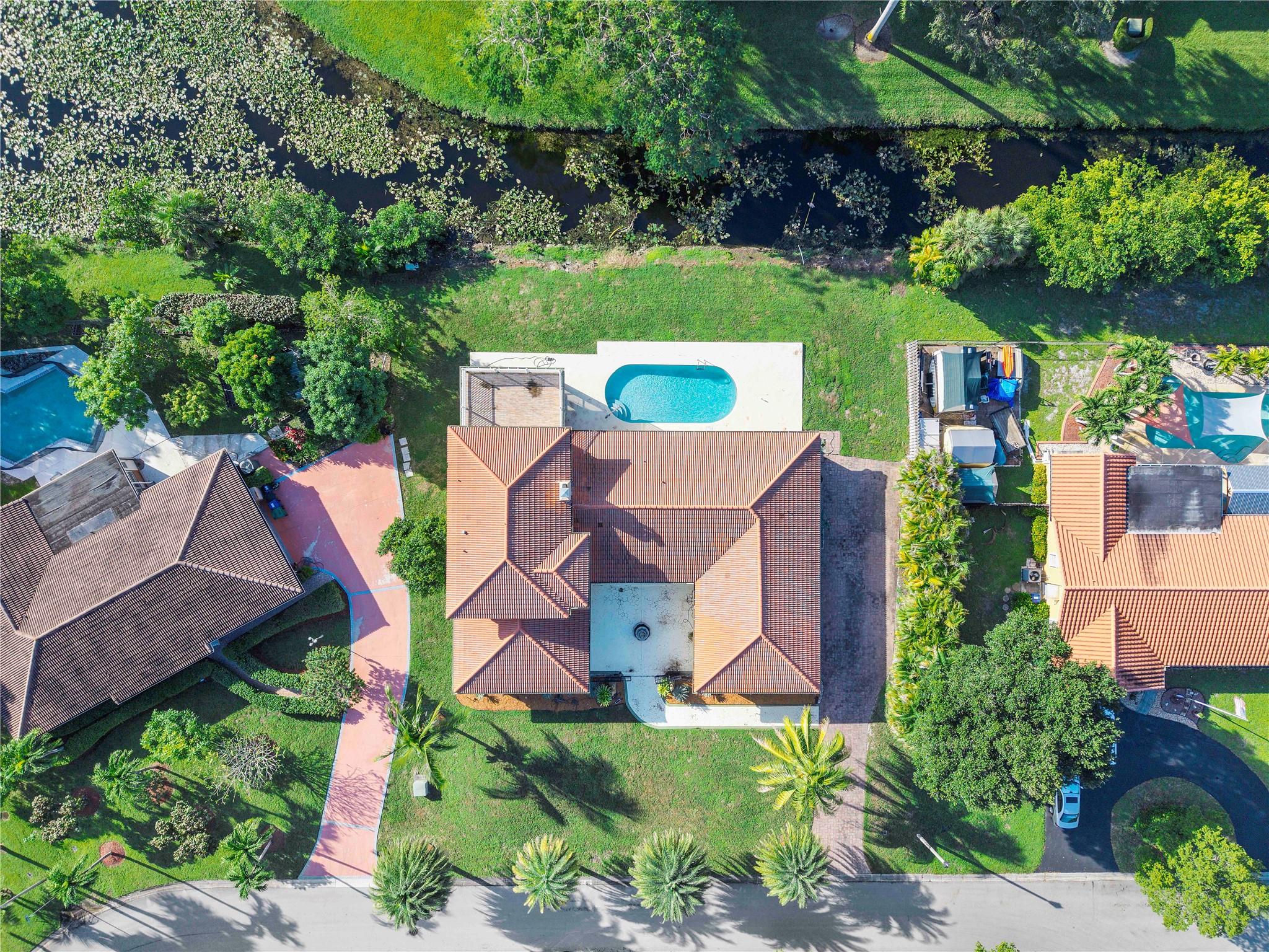 Fabulously & Beautifully Large home with a welcoming front courtyard. Sited on an expansive waterfront lot featuring an intensive variety of mature exotic fruit trees. Oversize living areas can accommodate a family who needs space. The Updated Island kitchen is impressive with its size & is perfect for large gatherings. Master Suite is a private retreat & offers a spa-like bathroom with a separate shower & whirlpool tub/balcony overlooking the grounds & pool area. Secondary bedrooms are on the first floor & are spacious. Huge screen porch with a full summer kitchen/newly resurfaced saltwater pool/large deck/tropical landscape & water frontage. Located in a quiet community in the heart of Coral Springs. Shopping, Dining, Schools & Places of Worship are within walking distance. NO HOA!!!