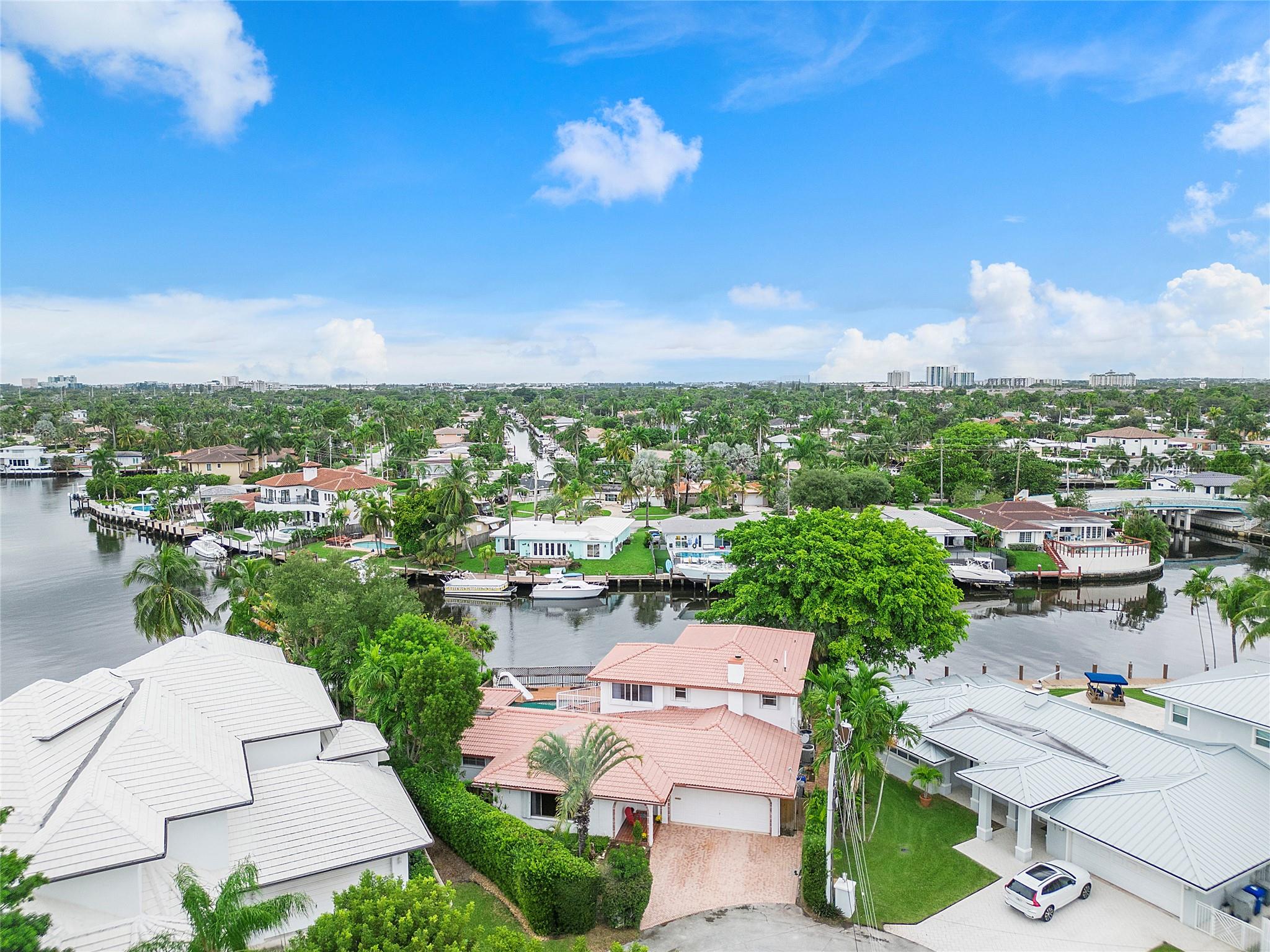 Views to die for! You may get lost in this special house with FOUR bedrooms, FOUR full baths. Neighborhood is a lovely, well-kept secret. Rarely available end of cul-de-sac lot on canal with one fixed bridge to Intracoastal and Ocean. Pool and spa with large deck and dock. Large open kitchen with a great design. Fireplace and Bar with pass thru window to pool deck. 3 bedrooms, 3 full baths and laundry room on first floor. Primary suite on the second floor with two HUGE closets, a big bathroom with spa tub, walk-in shower, toilet and bidet. Even a mini kitchen between the bedroom and sitting room. Two car garage. FOUR mile drive to beach! Close to restaurants, shopping, highways, golf, pickleball, the airport. Near great schools like Pine Crest. Come visit. Ready for you to make it yours.
