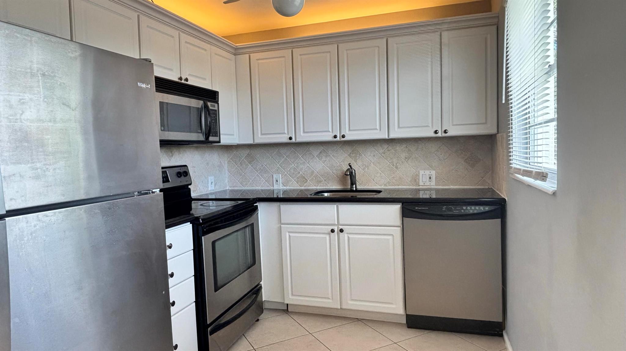 Updated end-unit featuring white kitchen cabinets, granite countertops, stainless steel appliances, ceiling fans, window treatments, and updated bathrooms. Enjoy all that Century Village , a 55+ community, has to offer--maintenance includes water, cable, internet, and access to a fantastic resort-style clubhouse. amenities include a full fitness center, performance theatre, party room, billiards rooms, indoor and outdoor pools, and more.Don't miss the opportunity to live in this highly desirable community at one of the most affordable prices. There are no credit or income requirements; the condo association does require a background check.