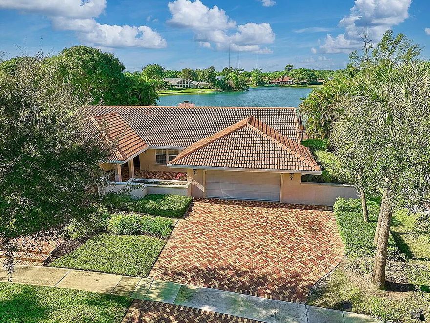 This home has not been on the market for almost forty years. Set within the exclusive guard-gated enclave of Estancia West, this single-story exceptional 4BR/2.5BA lakefront property captures one of the most breathtaking waterfront settings in Boca Raton. Overlooking the largest lake in the community, the residence offers panoramic water views, extraordinary privacy, and vibrant sunsets that transform daily living into a tranquil retreat. Exclusive use of an An expansive greenbelt extending from the rear of the property to the lake enhances both the sense of space and the uninterrupted natural views, giving the homesite a uniquely open and private feel. It creates a ''virtual lot size'' far exceeding the tax record. This makes the property physically superior to any home backing up to a neighbor or a busy street. Unlike "canal-view" lots, this property sits on the widest expanse of the community's largest lake. After reviewing the stunning sunset images, it should be clear that that the property isn't just "lake side", it's a front-row seat to one of the most expansive water views in Boca Raton. The images confirm that the home sits on a "Point Lot" where the horizon feels infinite, a feature that justifies a significant "Scarcity Premium" over standard community sales.

Water views immediately command attention upon entry and remain a defining feature throughout the home's primary living spaces, including the living room, family room, kitchen, breakfast area, and the primary suite and bath. Unlike "canal-style" lake lots, a "Big Lake" lot in Estancia West is valued for its long-view corridor. The "six room" water views from every major living area (Family, Kitchen, Dining, Living, Master, and Master Bath) is statistically rare.

The peaceful lakeside environment invites native birds and natural beauty, creating a calm, resort-like atmosphere year-round. Five sets of French doors seamlessly connect the interior to a spacious brick-paver terrace and pool area, creating an ideal setting for entertaining or relaxing beside the water. Matching pavers extend across the driveway and courtyard, enhancing the home's curb appeal, while the two-car garage and oversized driveway provide generous parking for seven vehicles.

In recent years, the owners did a high-end, absolutely beautiful renovation. There is a massive difference between a "Renovated to Sell" home and a "Renovated to Live" home. The owners' substantial investment was made with the intent of staying forever. The only reason that the home is now being offered for sale is that after 38 years in the home, the owners are open to moving to a country club community. If it does not work out, they intend to live in the home for their remaining life. The interior has been thoughtfully renovated with a fresh, modern aesthetic, clean, contemporary design and durable finishes. Wide-plank porcelain flooring sourced from Spain runs throughout most of the living areas, complemented by light wood-tone flooring in the bedrooms. The home is entirely carpet-free. The kitchen is designed for both everyday living and entertaining, featuring premium KitchenAid stainless steel appliances, an induction cooktop, oversized French-door refrigerator, convection oven and microwave, warming drawer, quartz surfaces, and a large island with extensive storage.
Soaring ceilings and skylights fill the home with natural light, enhancing the bright, open layout. A wood-burning fireplace provides a warm focal point, while the spacious design easily accommodates large gatherings. When opened, the French doors create a seamless transition between indoor and outdoor living, expanding the entertaining space to include the poolside terrace and lake beyond.

Additional highlights include dual-zone climate control with two recently installed Carrier high-efficiency air conditioners, a newer water heater, and impact-resistant windows along the front and sides of the residence. The covered patio is protected by a Miami-Dade-rated Armor Screen system engineered for extreme wind resistance, offering storm protection without sacrificing light or visibility. The Armor Screen enables patio furniture and planters to remain outside during hurricane season. An easily removable child safety fence surrounds the pool for added flexibility.

Estancia West is known for its beautifully maintained grounds, controlled access, and central Boca Raton location, offering convenient proximity to major highways, shopping, and dining. Residents enjoy access to a private park with tennis and pickleball courts, basketball court, playground, and shaded gathering areas. The property is located within the boundaries of highly regarded public schools, including Del Prado Elementary, Omni Middle School, and Spanish River High School, with numerous respected private schools nearby.

An uncommon and highly valued convenience, the home is a half mile walk to an Orthodox Boca Raton Jewish Center through the private community park. Once through the combination locked gate in the shared wall with the Boca Raton Jewish Center, the entrance to the Boca Raton Jewish Center is only yards away. The half-mile park walk, followed by the private gated entry to the Boca Raton Jewish Center, transforms the utility of the home. This is a crucial distinction: it offers a peaceful, safe, and beautiful walk completely removed from public traffic or busy roads like Glades. For some, it solves a major lifestyle hurdle.

The designated community bus stop is located within the gated walls. The home is located approximately 100 yards from school bus stop. The bus stop can be seen from the back yard. 

This property presents a rare chance to own a private waterfront residence in one of Boca Raton's most established and sought-after gated communities, combining scenic beauty, beautifully renovated, and an exceptional location.