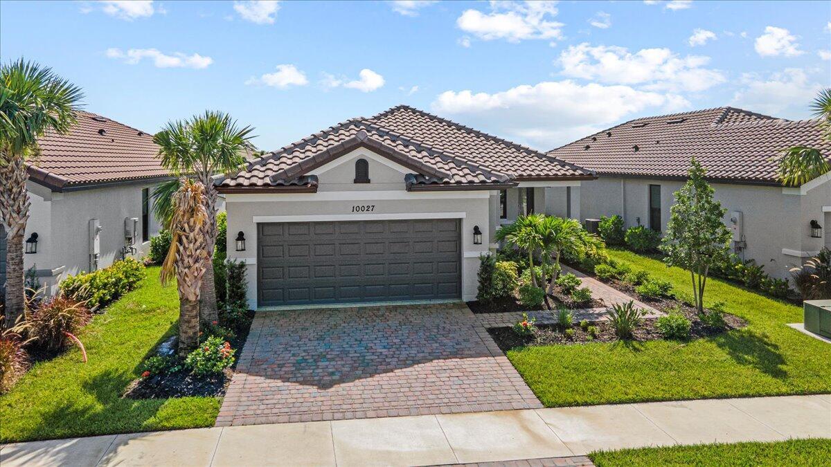 Fabulous ''Bergamo'' Model built in 2024 at Esplanade at Tradition (55+ Community). This beautifully upgraded home shows like a Model! Features CBS Construction, tile roof, paver driveway, hurricane impact windows & covered entrance. Host 2 BR's, Den/Office, 2 BA's, 2 CG & screen enclosed Lanai, black aluminum fenced in yard with private lake view. Details include volume ceiling, open floor plan with stunning gourmet kitchen offers large island, stainless steel upgraded GE Cafe appliances, quartz counter tops, mother of pearl back splash, custom pantry & farm sink. Split floor plan, custom lighting throughout, interior freshly painted with Benjamin Moore paint, beautiful wall paper in bathrooms & tile flooring. This community offers exceptional amenities to feel like you live in a RESORT!