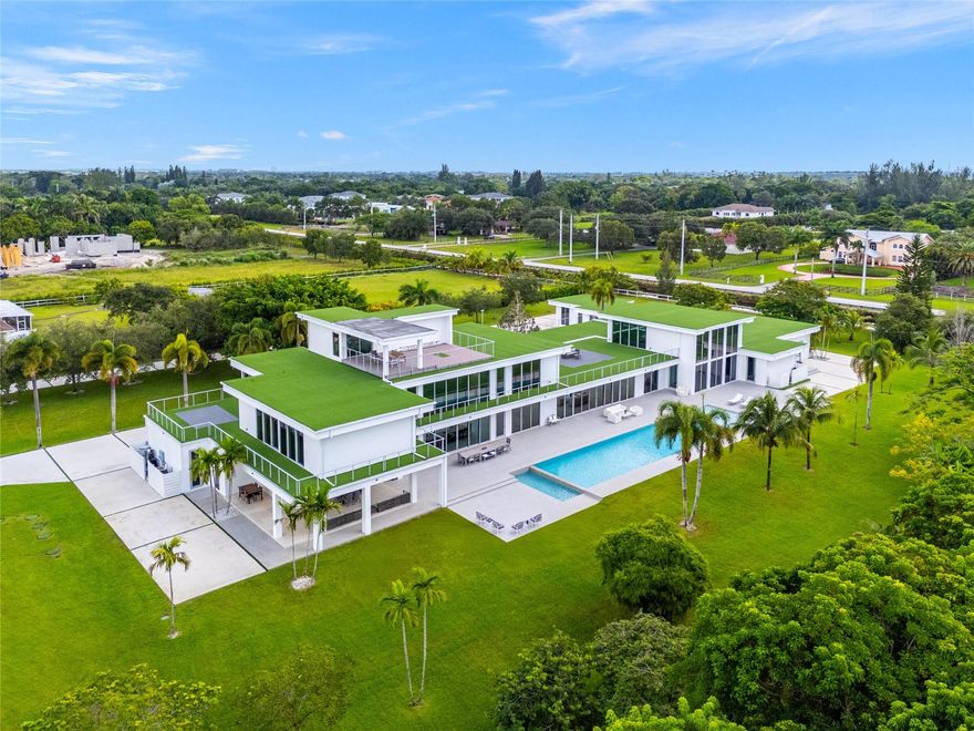 Welcome to the most extraordinary modern estate in Southwest Ranches, situated on 4+ acres at the end of a cul-de-sac & bordered by a canal. This architectural masterpiece offers features floor-to-ceiling windows, soaring ceilings & an open floor plan that seamlessly connects indoor & outdoor spaces while offering flexibility for customization. The estate is perfect for both living, entertaining & the avid collector. Highlights include a 19,000+ sq ft finished rooftop ideal for lounging, entertaining or displaying art, gated entrance, infinity-loop driveway, indoor & outdoor pools, multiple workspaces, wine display room & smart home features. Enjoy ultimate privacy & luxury just minutes from the urban conveniences of South Florida. Contact agent for pricing on leases less than 12 months.