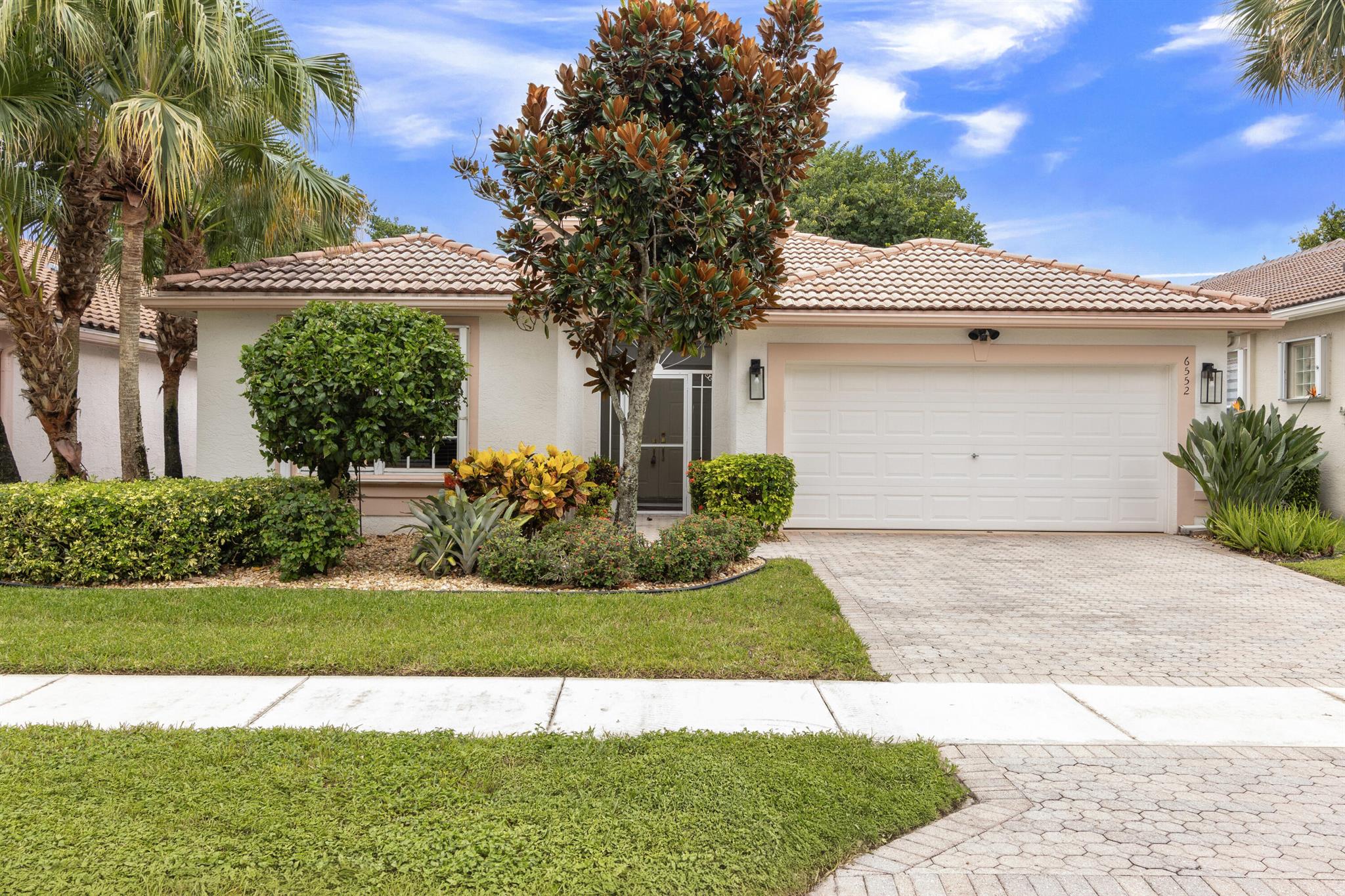 Well loved Coral Model situated on a private garden lot! This true 3 bedroom, 2 bath home features tile on the diagonal (NO Carpets). White kitchen updated with quartz countertops, quartz backsplash and s/s appliances. A/C and Hot Water Heater approximately 4 years old! Large primary bedroom w/ bay window and his/her closets. Primary bath equipped with his/her sinks, separate shower with updated glass door and separate tub. 2nd bathroom upgraded with a shower. Laundry inside. 2 Car Garage. Accordion shutters. Private large sized screened lanai with tile flooring and new ceiling fan is perfect for relaxing or entertaining guests. Valencia Isles renovated clubhouse features a Bistro and amenities to keep you busy all week long! 4 Additional pickleball courts and 2 Bocce courts coming soon!