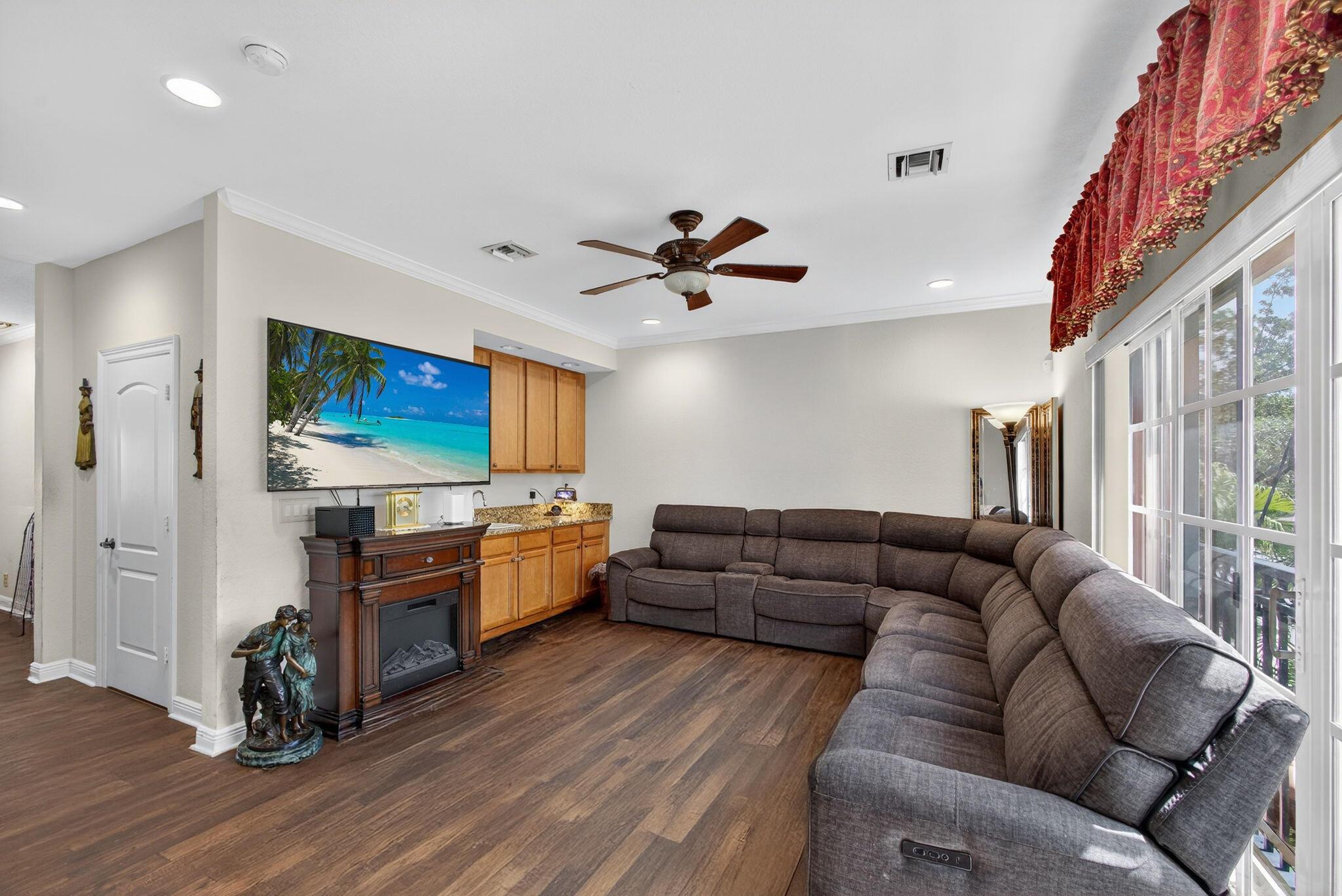 In the heart of Lake Worth Beach, just 2.5 blocks from the Intracoastal, this 3-level townhome offers a spacious, 1,727 sq ft floor plan & several recent upgrades. The Pergo Chester Ridge Hickory laminated flooring on all levels is less than 3 years old. One full bedroom & full bath are on the ground level. High ceilings throughout. The carpeting is less than 2 months old. The main level features crown molding & a kitchen with 2024 KitchenAid appliance set & a Samsung convection oven. Dedicated laundry room off the kitchen with a 2024 W/D & cabinetry. Attached to the kitchen is a formal dining room. There is great natural light & the windows face out to the pool & downtown. The living room features a full wet bar & views of the palm trees in your front yard. 2-ton HVAC system is 2021 &