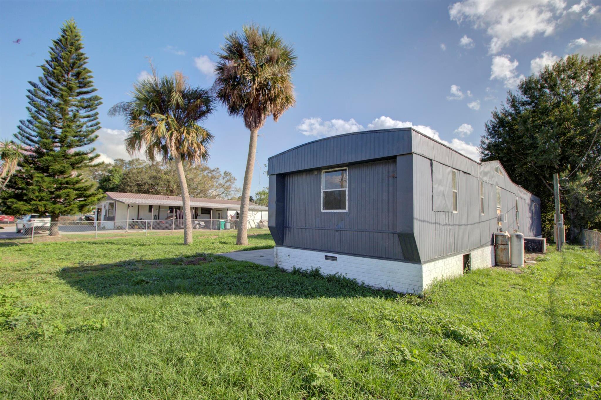 Treasure Island - Canal front 3-bedroom mobile home on a flat, cleared, fenced lot in Okeechobee. This fixer-upper is currently leased for $1,000/month, offering great investment potential.