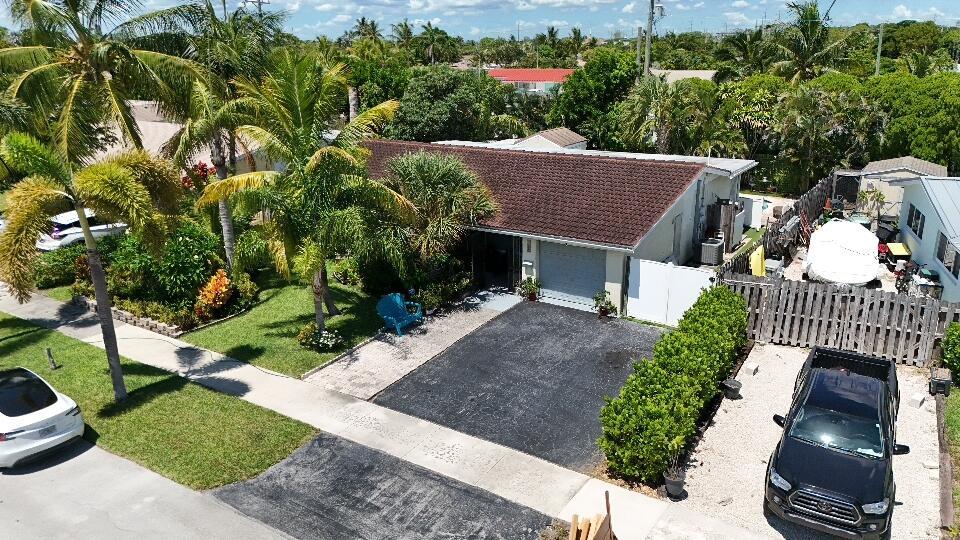 Great Single Family pool home with excellent location under 10 minutes to the beach and no HOA fees or restrictions. Tastefully redone kitchen with Cambria Quartz, stainless andwhite Shaker cabinets, updated baths, gleaming terrazzo floors and an open flowing layout that makes entertaining a joy! Owner has removed the popcorn ceilings, and added distressed wood accents, plantation shutters and converted the garage to a large bonus room that could be an office. Large family room can be converted to a third bedroom..Owner made their own fitness space. New roof and flat roof 2019, new A/C w HALO air purification 2020, tankless water heater 2020; whole house water purification, keyless entry and hurricane rated shed. Come enjoy this great Swimming pool with a tiki bar to bring friends over.
