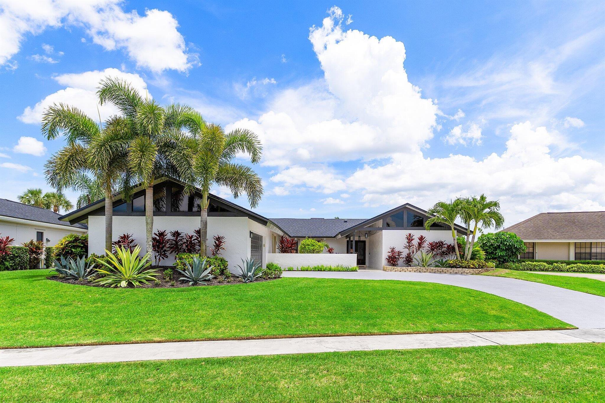 Welcome to your dream waterfront home on Lake Wellington! NO HOA, zoned for all A rated schools and conveniently close to shopping, dining, and the famous Winter Equestrian Capital of the World. This stunning 3-bedroom, 2.5-bathroom residence boasts an impressive 2,480 square feet of living space and a BRAND NEW roof. The two A/Cs were replaced in 2023/2024 and water heaters in 2020/2021. As you walk past the covered and travertine walkway, notice the 2nd entryway - perfect for MULTIGENERATIONAL living or an office space. Inside, you're greeted by a open layout filled with natural light. The vaulted ceilings, exposed beams, and decorative finishes create an inviting atmosphere that is both elegant and relaxed.