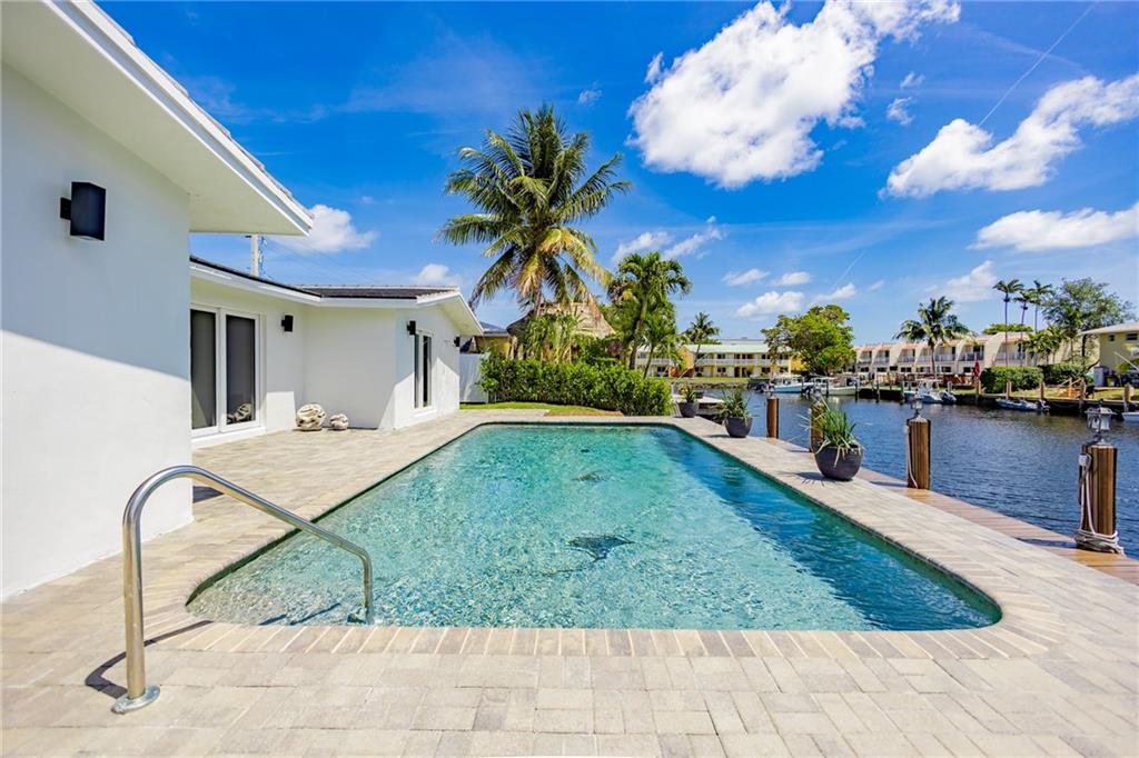A truly stunning, fully renovated WATERFRONT gem! This unique property boasts 3 bedrooms and 2 baths in the main house and an attached 1 bedroom 1 bath studio apartment with private entrance. The backyard space has a large pool overlooking 60’ of dockage with ocean access and only 1 fixed bridge. Beautifully updated with new concrete tile roof, high end finishes, large profile La Fenice ICON Italian tile flooring, impact sliders leading to the pool area from bedrooms as well as impact windows throughout, open concept kitchen with new Samsung appliances, 2 car garage. This home is close to everything the locals love about Pompano Beach & a must see!
