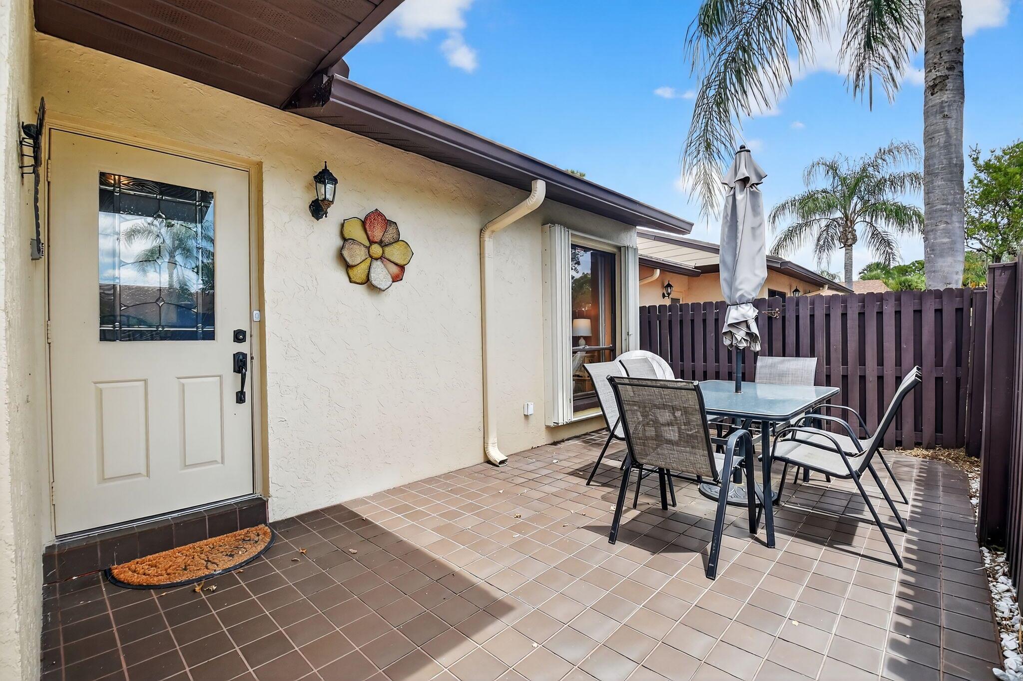 Enter through an expansive, private front patio into your villa and be immediately greeted by a pretty water view. This immaculate, all-ages, turnkey home has soaring ceilings with a skylight that bathes the living area in natural light. Most of the beautiful furniture is included (can be purchased empty too). Amenities are conveniently located a short stroll away. Features include a new electric panel, a home warranty until 12/31,a spacious Florida room, hurricane shutters, newer bathroom vanities, new fridge, walk-in closet, 0 carpet and an assigned parking spot directly in front. Association covers roof maintenance and replacement plus building insurance. All-ages Pine Ridge North II amenities include a clubhouse, a pool, tennis courts, bocce ball and shuffleboard. A must see!