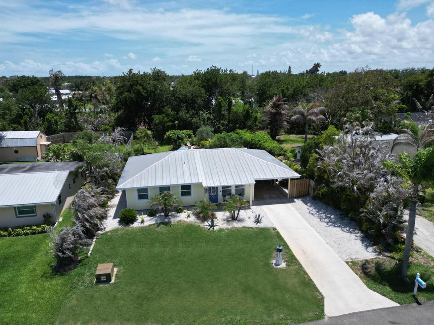 Fully renovated absolutely move-in ready, this 2-bedroom, 2-bath home on a quiet cul-de-sac street in desirable Hobe Sound. Featuring a durable metal roof and full storm protection, this home offers both style and peace of mind.  Inside, you'll find beautiful porcelain flooring, elegant cove molding, and a bright, open layout. The updated kitchen boasts white shaker cabinets, granite countertops, and ample storage, while both bathrooms have been tastefully renovated with stunning tile finishes.  Step outside to a lush, naturally landscaped backyard that offers privacy and a tranquil setting—perfect for relaxing or entertaining. With room to expand or add a pool.  This is one of the nicest 2 Bedroom homes I've ever offered for sale. NO HOA. Close to the Beach and Intracoastal.