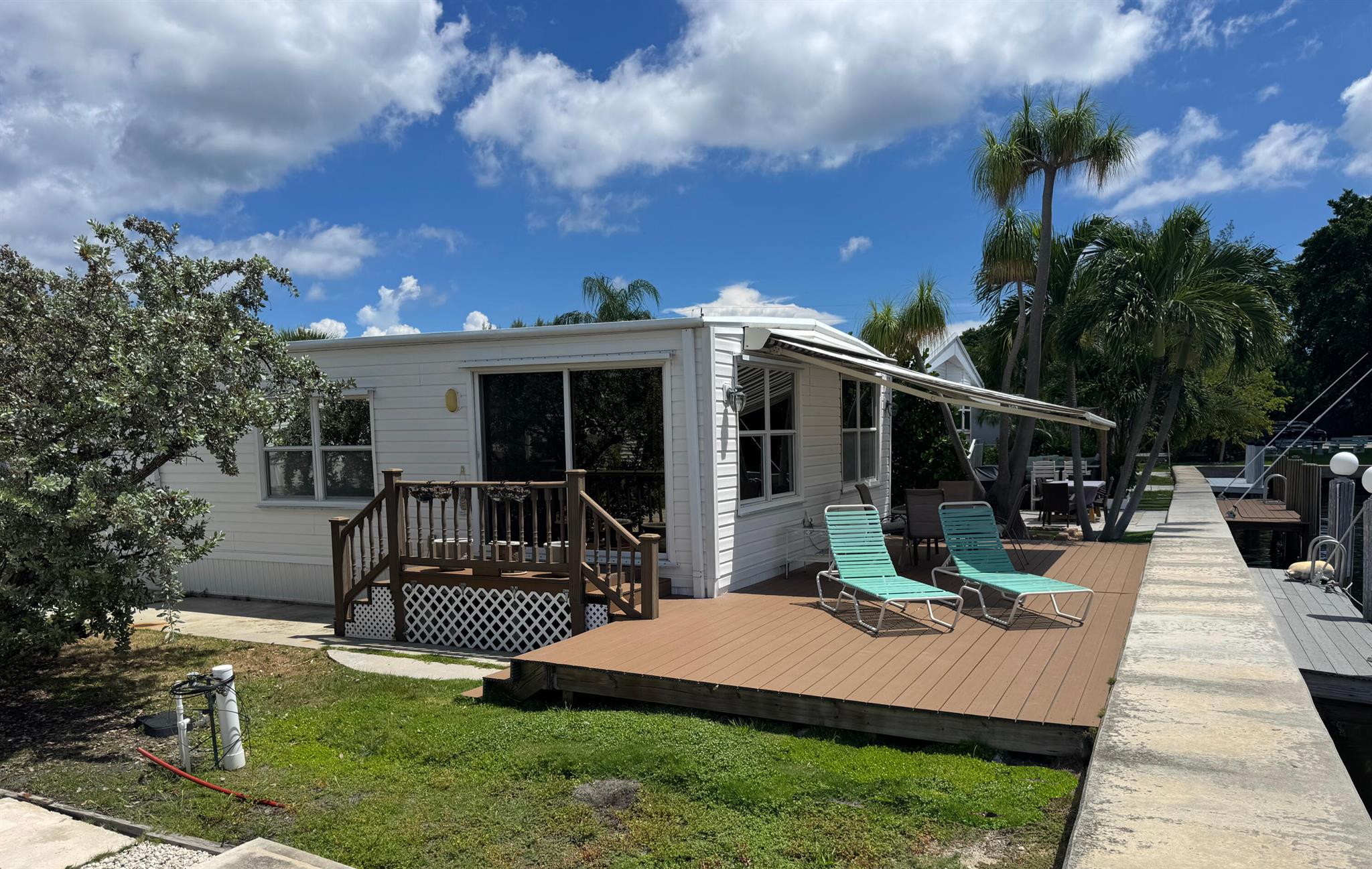 Nice double wide unit ON THE CANAL WITH A DOCK and a 400SF+/- deck with retractable electric awning. 2 bedrooms 1-1/2 baths. Large living area with expansive windows and wonderful views. Large open kitchen with lots of cabinet storage and a pantry closet. Complete with breakfast bar and a designated dining area. 12x16 Primary bedroom with private bath and laundry area. Second bedroom has a walk in closet, 1/2 bath access and private entry door. This unit has a full driveway for parking. This is truly a great unit offering you 46 shares of paradise.