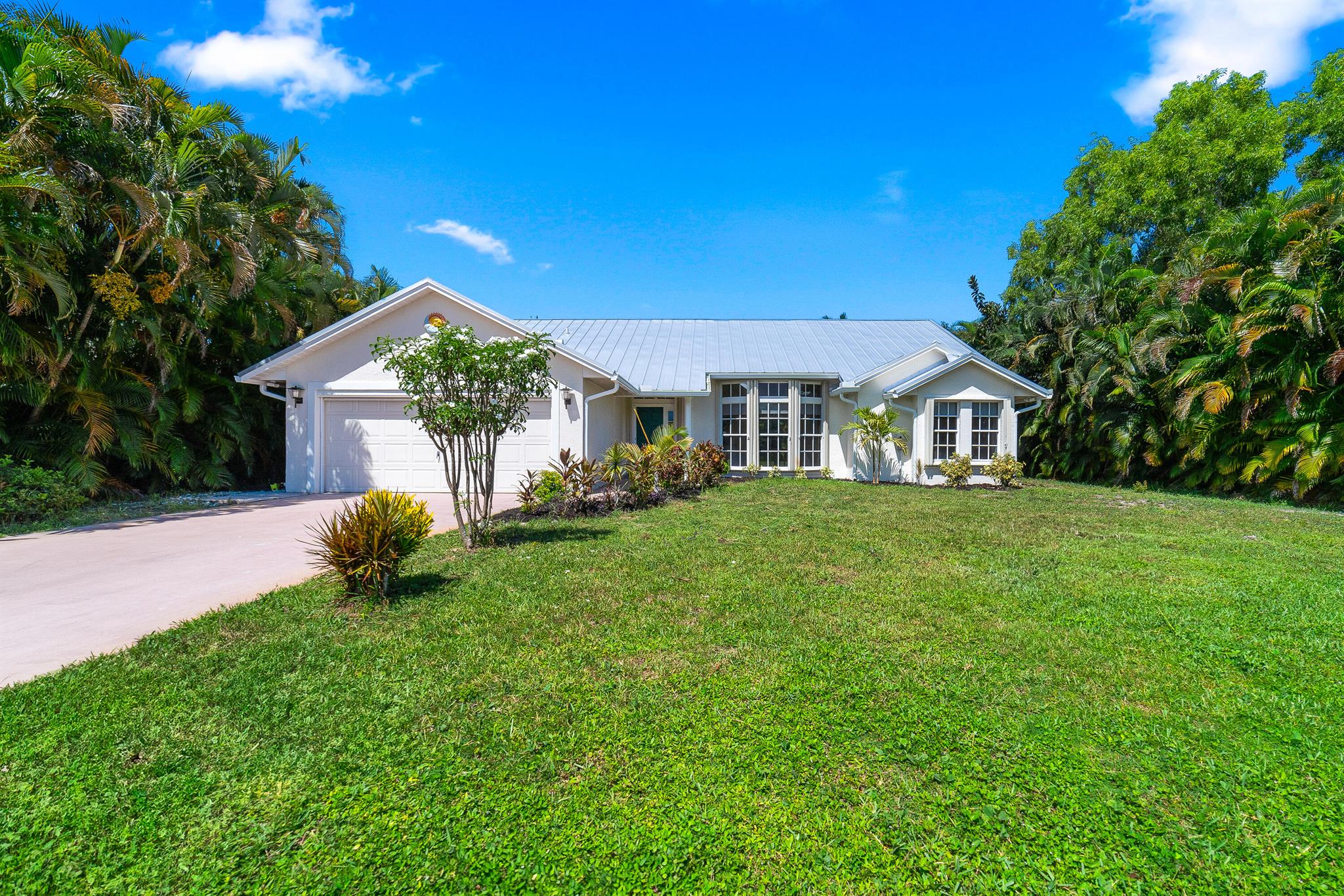 Experience the perfect blend of modern luxury and charm in this beautifully renovated home, just 12 minutes from the beach and steps from the tranquil Savanna Preserve. Featuring a brand-new 50 year seamless metal roof with gutters, a 2025 air conditioning system, and freshly cleaned ducts, this property offers peace of mind for decades to come. Inside, the open-concept split floor plan boasts a stunning chef's kitchen with a 12-foot granite island, custom cabinetry, and top-of-the-line appliances, all overlooking spacious living areas filled with natural light. The primary suite opens directly to a private patio, while the lush, tropical yard, lined with 30-foot palm trees, ensures complete seclusion.