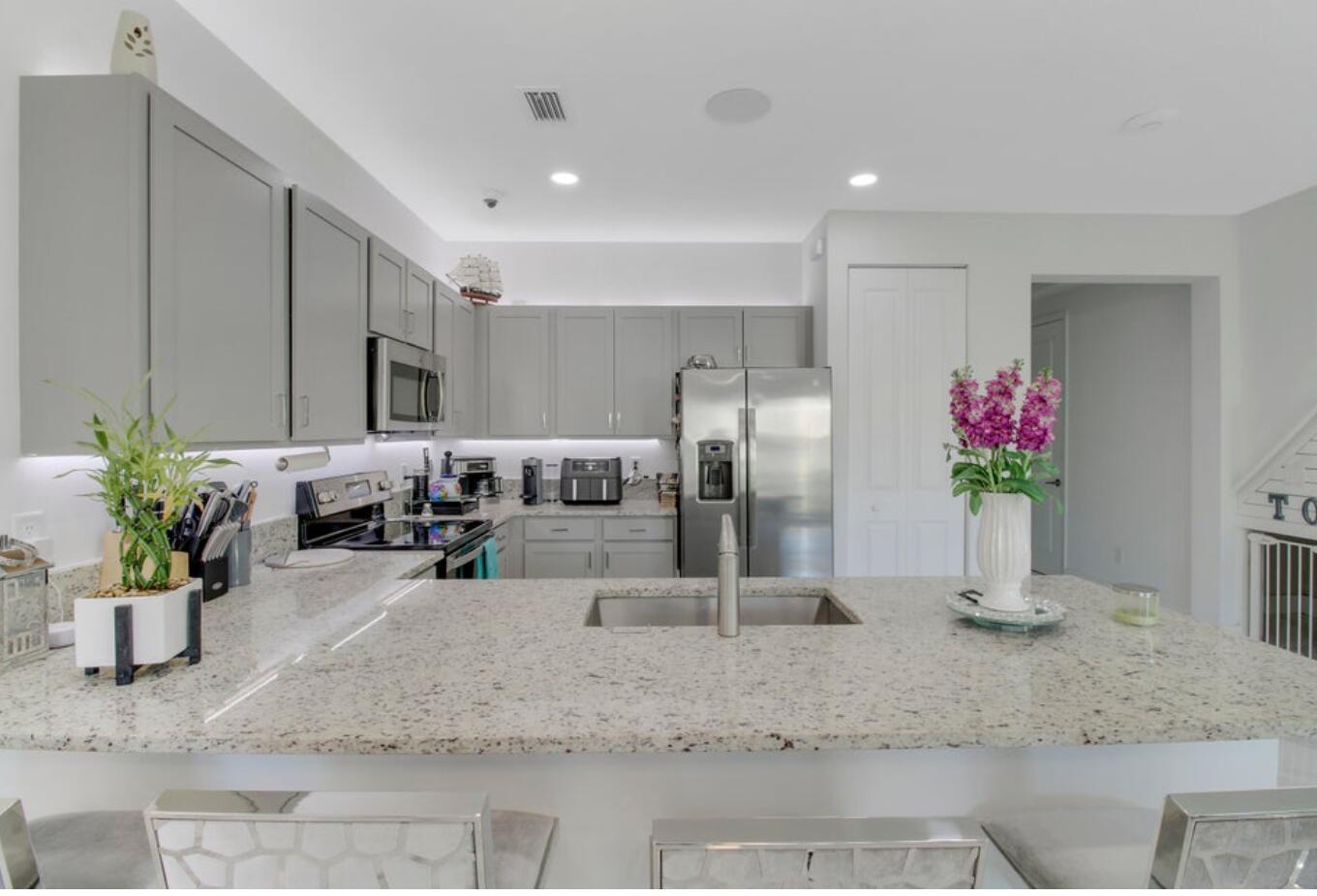 This beautifully updated 4-bedroom, 2.5-bath townhome features sleek porcelain tile flooring and a redesigned backyard for effortless indoor-outdoor living. The open-concept layout is filled with natural light, offering spacious living and dining areas perfect for gathering and entertaining. Upstairs, comfortable bedrooms provide privacy and relaxation, while a convenient laundry closet adds everyday ease. Enjoy a serene outdoor retreat, plus a single-car garage and two additional driveway spaces. Community amenities include a pool, fitness center, and play area. Ideally located near I-95, the Turnpike, beaches, shopping, and dining, this home offers stylish, low-maintenance living in an unbeatable location.