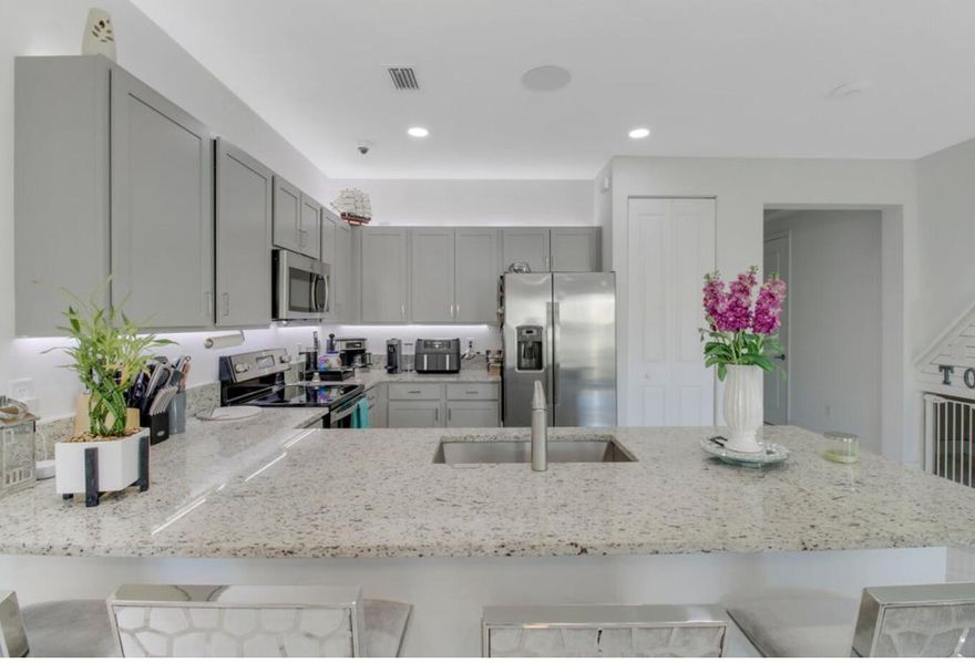 This beautifully updated 4-bedroom, 2.5-bath townhome features sleek porcelain tile flooring and a redesigned backyard for effortless indoor-outdoor living. The open-concept layout is filled with natural light, offering spacious living and dining areas perfect for gathering and entertaining. Upstairs, comfortable bedrooms provide privacy and relaxation, while a convenient laundry closet adds everyday ease. Enjoy a serene outdoor retreat, plus a single-car garage and two additional driveway spaces. Community amenities include a pool, fitness center, and play area. Ideally located near I-95, the Turnpike, beaches, shopping, and dining, this home offers stylish, low-maintenance living in an unbeatable location.
