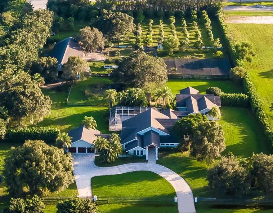 Serene sanctuary in Boca Raton's Horseshoe Acres. Private gates open to 5 acres of lush, tropical landscaping. Fully fenced with security gate, 150 fruit and clusia trees frame the property leading to the 7000- SqFt estate. 

Luxurious main house features 4 bedrooms, gourmet kitchen, open living room, formal dining, exercise room and fireplace. Unique appointments include rare walnut flooring throughout the home made from 100-yr old Amish barn wood. Step outside for the perfect relaxing getaway or ideal spot for entertaining.  

The Equestrian Estate is located in the private community of Horseshoe Acres situated on over 190 acres of lush tropical landscaping and tree-lined streets. This equestrian community is one of the only neighborhoods in Boca Raton that allows residents and homeowners to raise horses on their private land.

This equestrian compound overlooks a magnificent barn featuring 5 paddocks, 7 stalls, 2 interior wash racks, tack up stalls, office, grooms quarters, feed room, tack room and private trails. 

Covered walkway leads to the 3 bedrooms, 3 bath guesthouse with full kitchen and large living area.