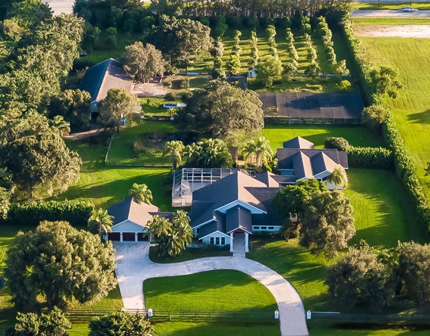 Serene sanctuary in Boca Raton's Horseshoe Acres. Private gates open to 5 acres of lush, tropical landscaping. Fully fenced with security gate, 150 fruit and clusia trees frame the property leading to the 7000- SqFt estate. 

Luxurious main house features 4 bedrooms, gourmet kitchen, open living room, formal dining, exercise room and fireplace. Unique appointments include rare walnut flooring throughout the home made from 100-yr old Amish barn wood. Step outside for the perfect relaxing getaway or ideal spot for entertaining.  

The Equestrian Estate is located in the private community of Horseshoe Acres situated on over 190 acres of lush tropical landscaping and tree-lined streets. This equestrian community is one of the only neighborhoods in Boca Raton that allows residents and homeowners to raise horses on their private land.

This equestrian compound overlooks a magnificent barn featuring 5 paddocks, 7 stalls, 2 interior wash racks, tack up stalls, office, grooms quarters, feed room, tack room and private trails. 

Covered walkway leads to the 3 bedrooms, 3 bath guesthouse with full kitchen and large living area.
