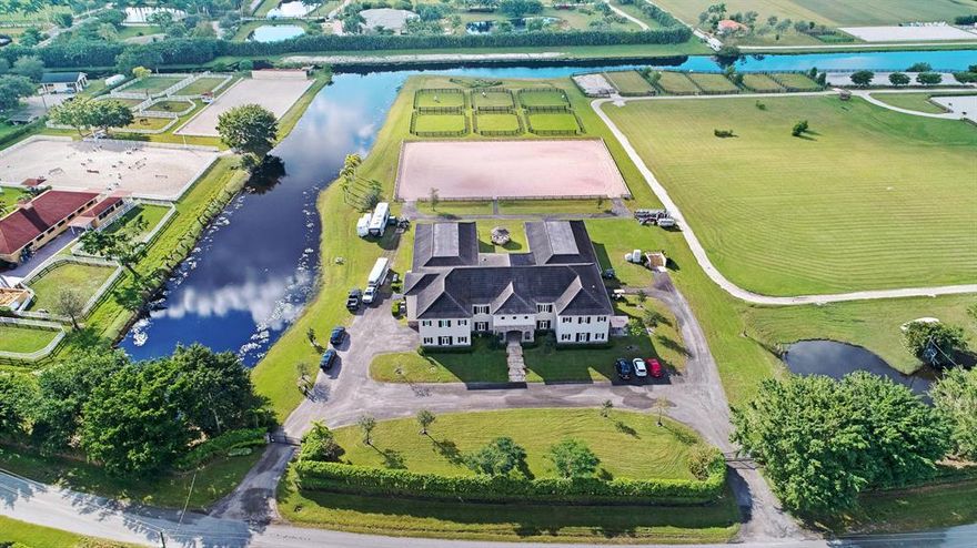 This exceptionally designed 5.5 acre equestrian facility in Palm Beach Point East offers the perfect combination of luxury and functionality. The barn consists of two 12 stall wings, each with their own feed and tack rooms, for a total of 24 stalls. It is complete with a 2 bedroom staff quarters, rider's lounge, office and 2 car garage. The extravagant living quarters boasts 5 bedrooms, 4.5 bathrooms, a media room and traditional dining and living spaces. This home was completed with top quality finishes and exceptional design choices. Set in a tranquil and private location, hacking distance to WEF, the farm includes a 140' x 205' ESI arena, great turnout, RV hookups and generous parking.